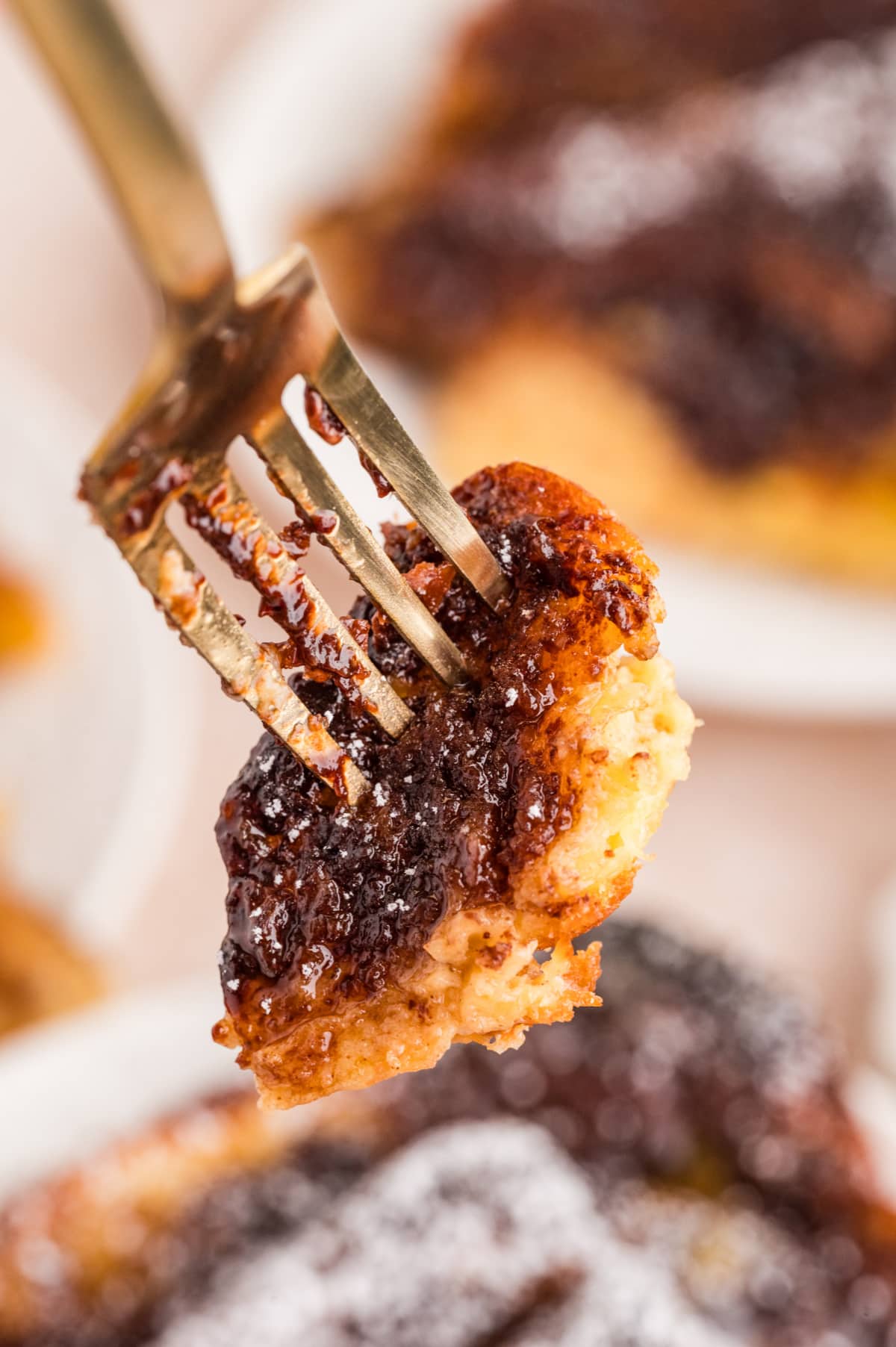 Forkful of Nutella French Toast Bake showing gooey chocolate hazelnut layers and soft custard-soaked brioche