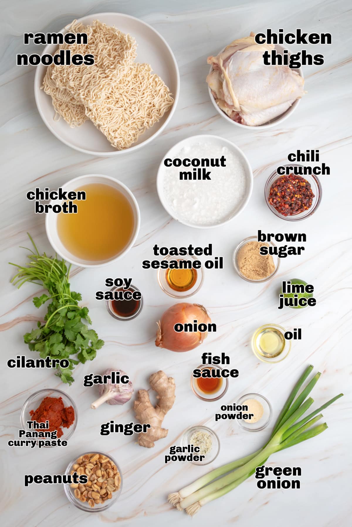 Thai curry ramen ingredients flat lay Ingredients for Thai curry ramen including ramen noodles, chicken thighs, coconut milk, Panang curry paste, ginger, garlic, soy sauce, fish sauce, sesame oil, brown sugar, lime juice, and peanuts