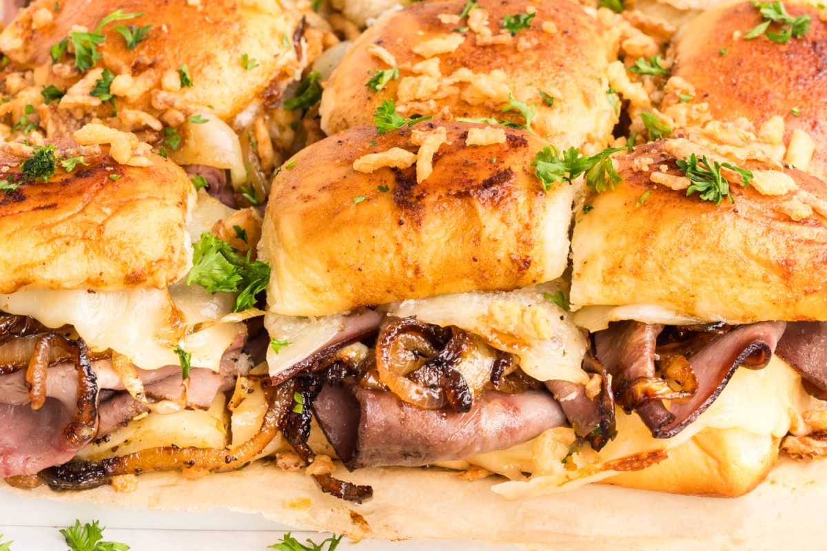 Baked French dip sliders packed with shaved roast beef, provolone cheese, caramelized onions, and crisp French-fried onions on sweet rolls French dip sliders with roast beef, melted provolone, caramelized onions, and French-fried onions