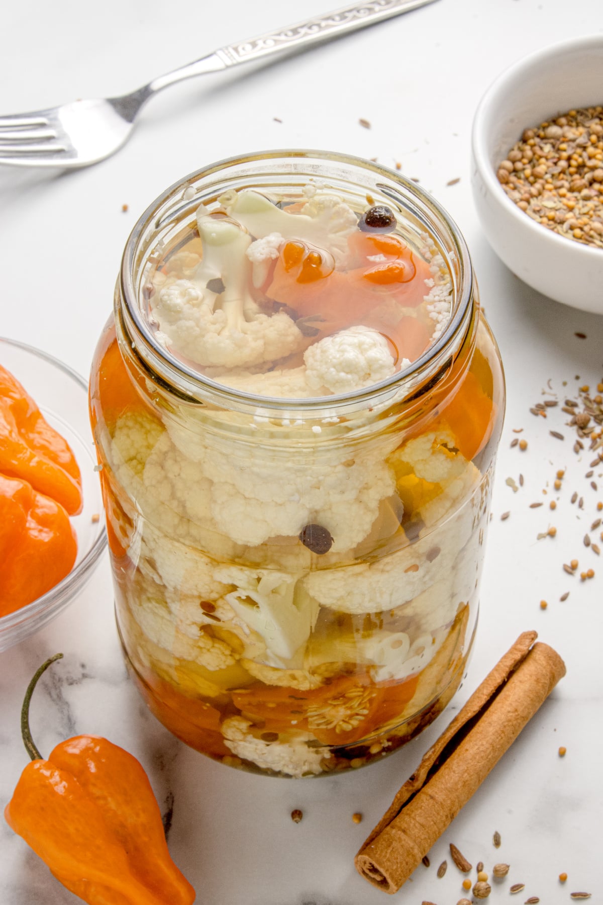 Close-up of spicy cauliflower refrigerator pickle with habaneros Hot pickled cauliflower in a mason jar with habanero peppers and whole spices in clear brine