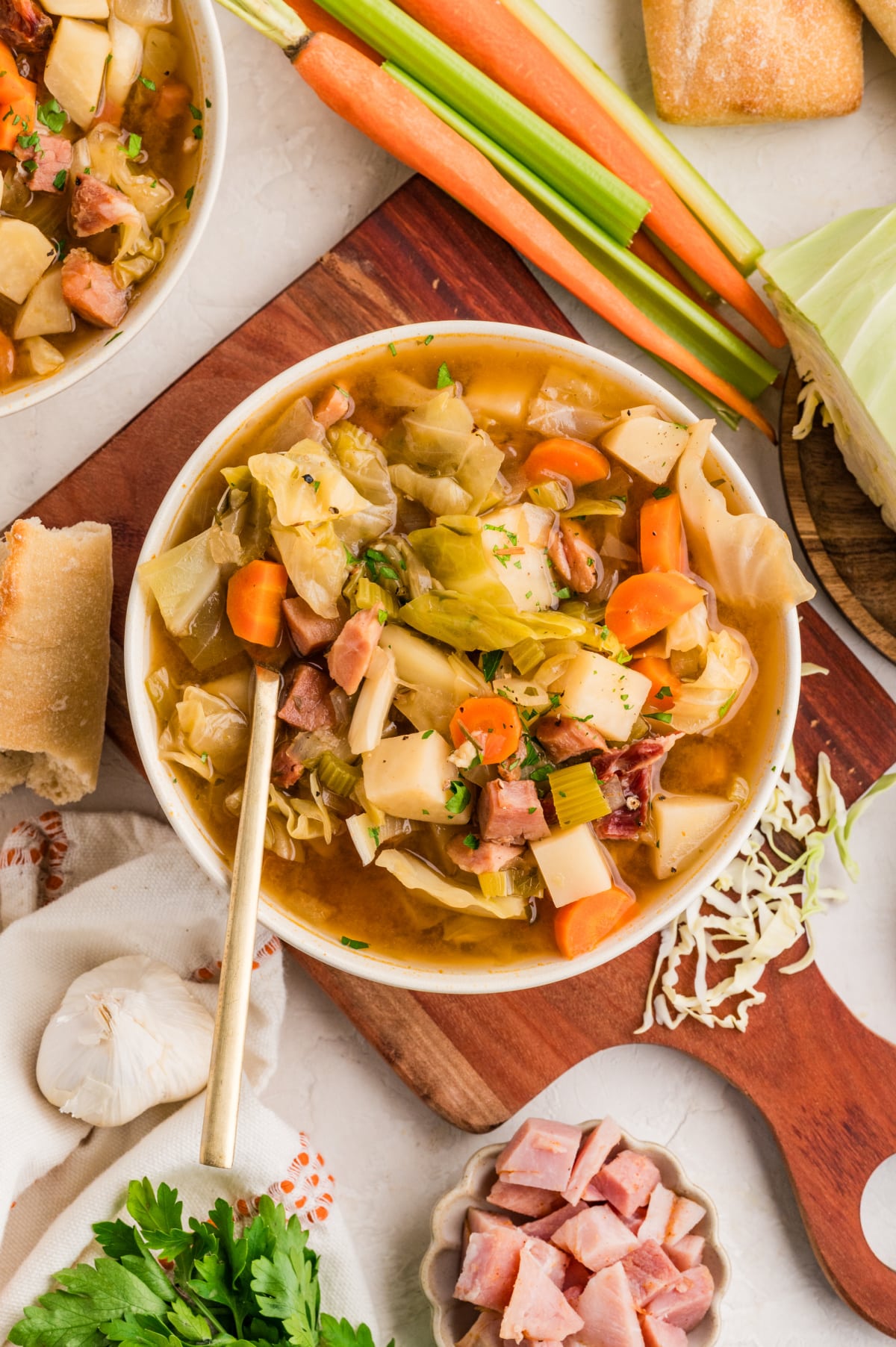 Cabbage soup with ham and vegetables Hearty cabbage soup with ham, potatoes, carrots, and celery in a brothy bowl