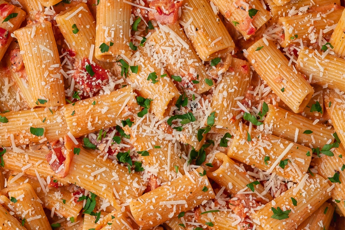 Close-up of Calabrian chili rigatoni with Parmesan, parsley, and creamy tomato sauce