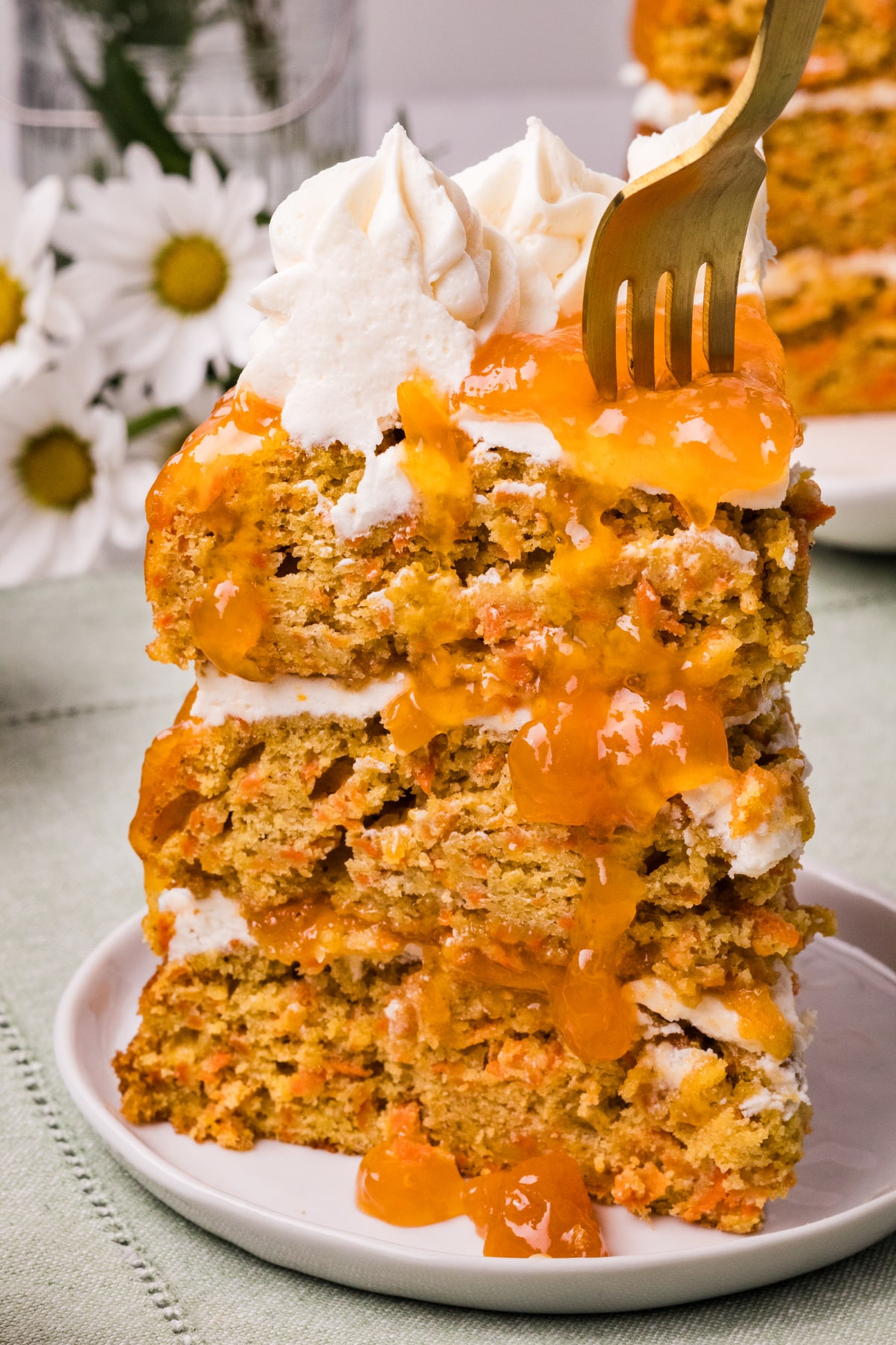 Carrot cake slice with apricot filling and frosting sliced carrot cake with a fork