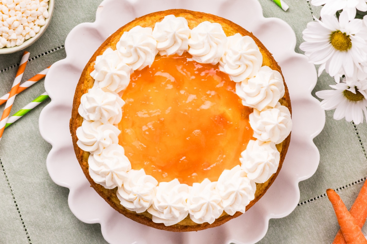 Carrot cake with apricot filling and white chocolate cream cheese frosting top view Top view of Carrot Cake with Apricot Filling and White Chocolate Cream Cheese Frosting with piped frosting border and apricot center