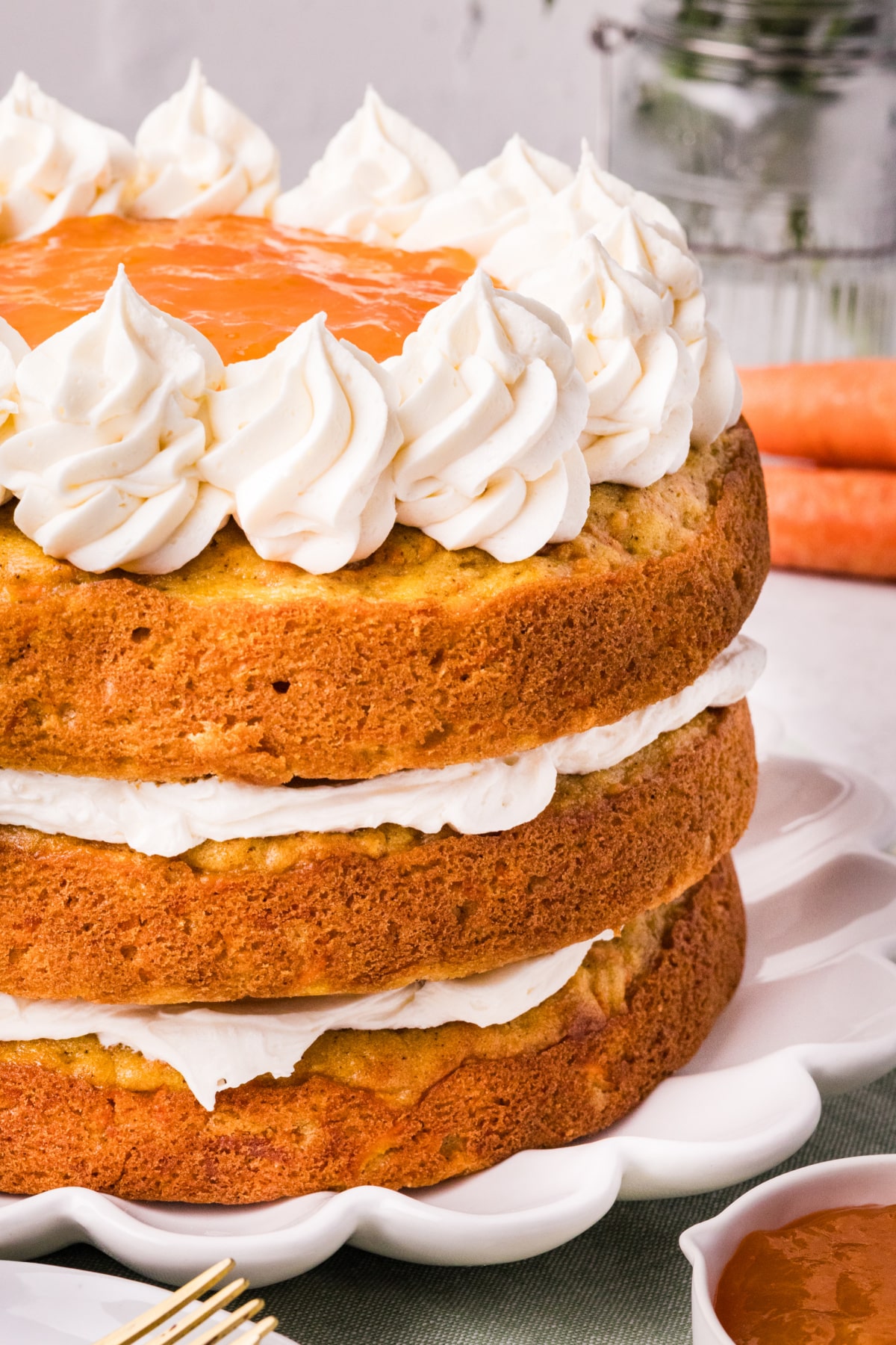 Carrot Cake with Apricot Filling and White Chocolate Cream Cheese Frosting Carrot Cake with Apricot Filling and White Chocolate Cream Cheese Frosting on a white scalloped cake stand