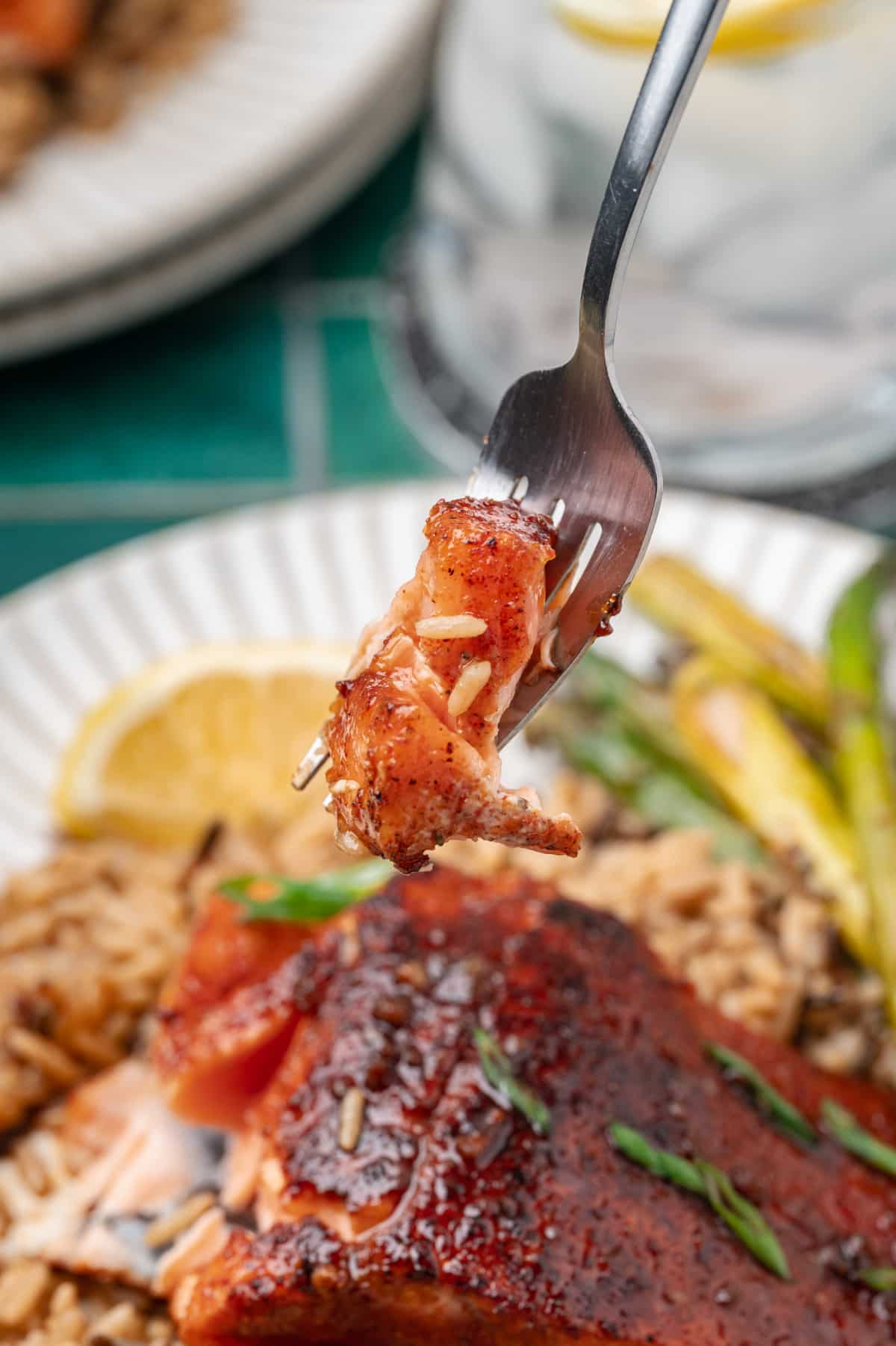 Flaky Pan Seared Salmon Bite fork holding a flaky bite of pan seared salmon with caramelized glaze and tender interior