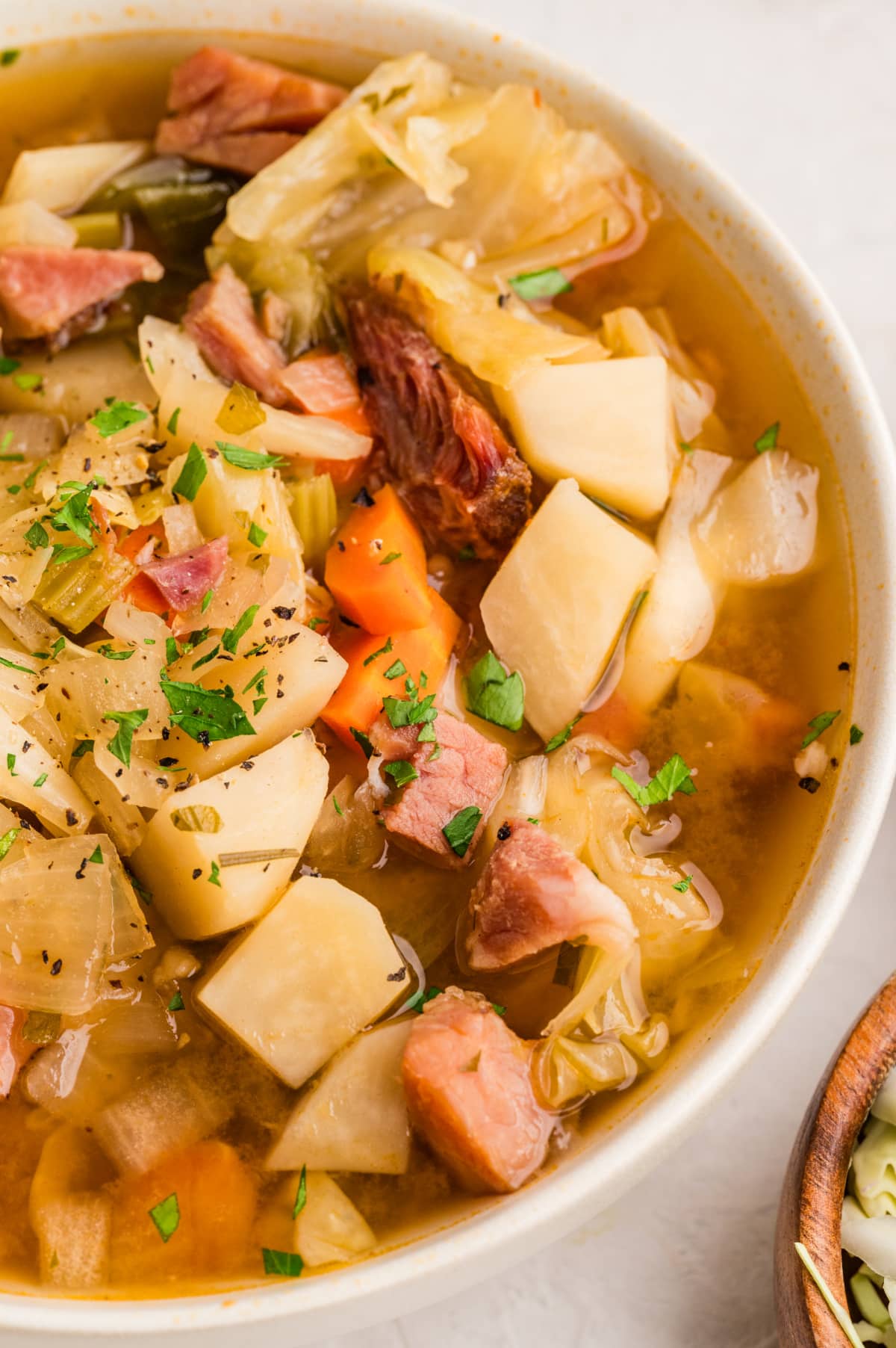 Ham and cabbage soup in a bowl Ham and cabbage soup with potatoes, carrots, cabbage, and chunks of ham in broth