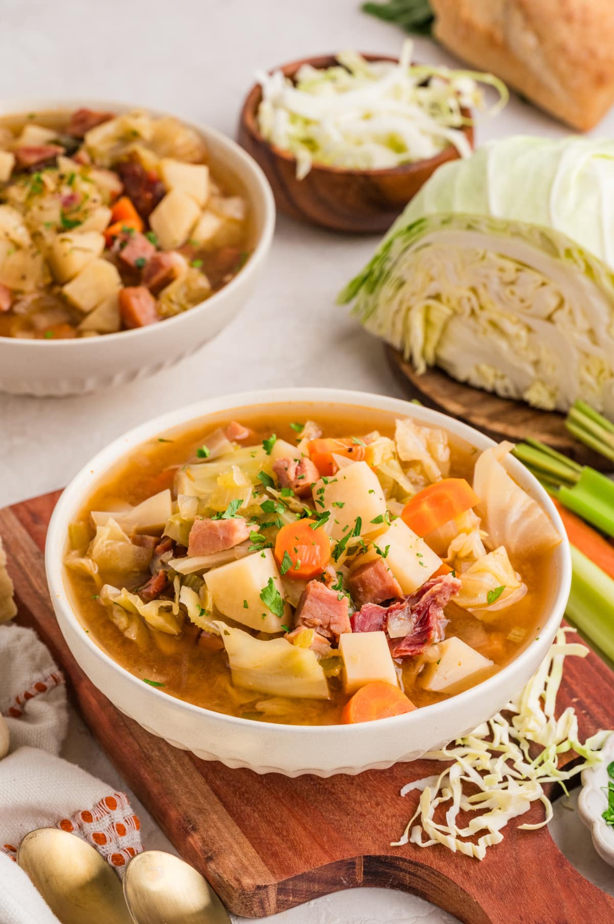 Ham and cabbage soup with cabbage and vegetables Ham and cabbage soup with potatoes, carrots, cabbage, and ham in broth with ingredients on the side