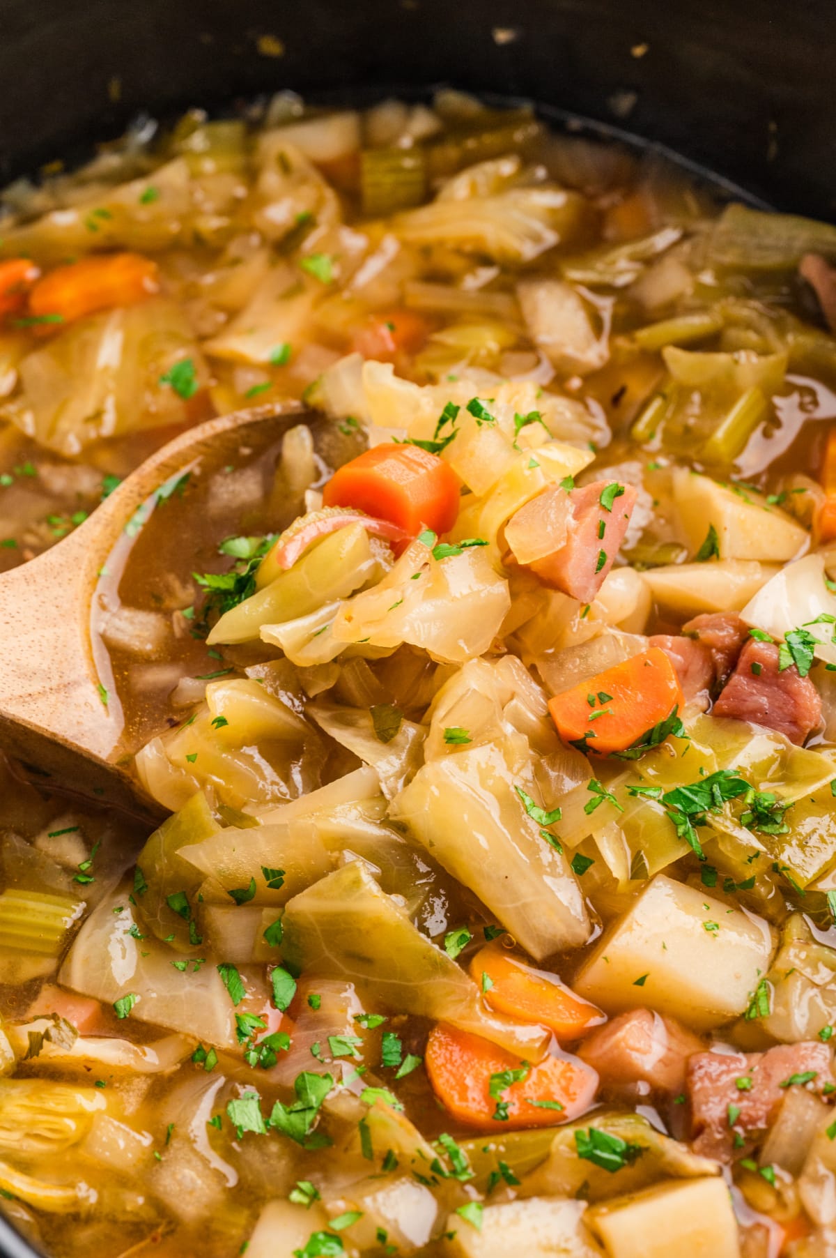 Ham cabbage soup cooking Ham cabbage soup cooking in a slow cooker with cabbage, potatoes, carrots, and ham in broth