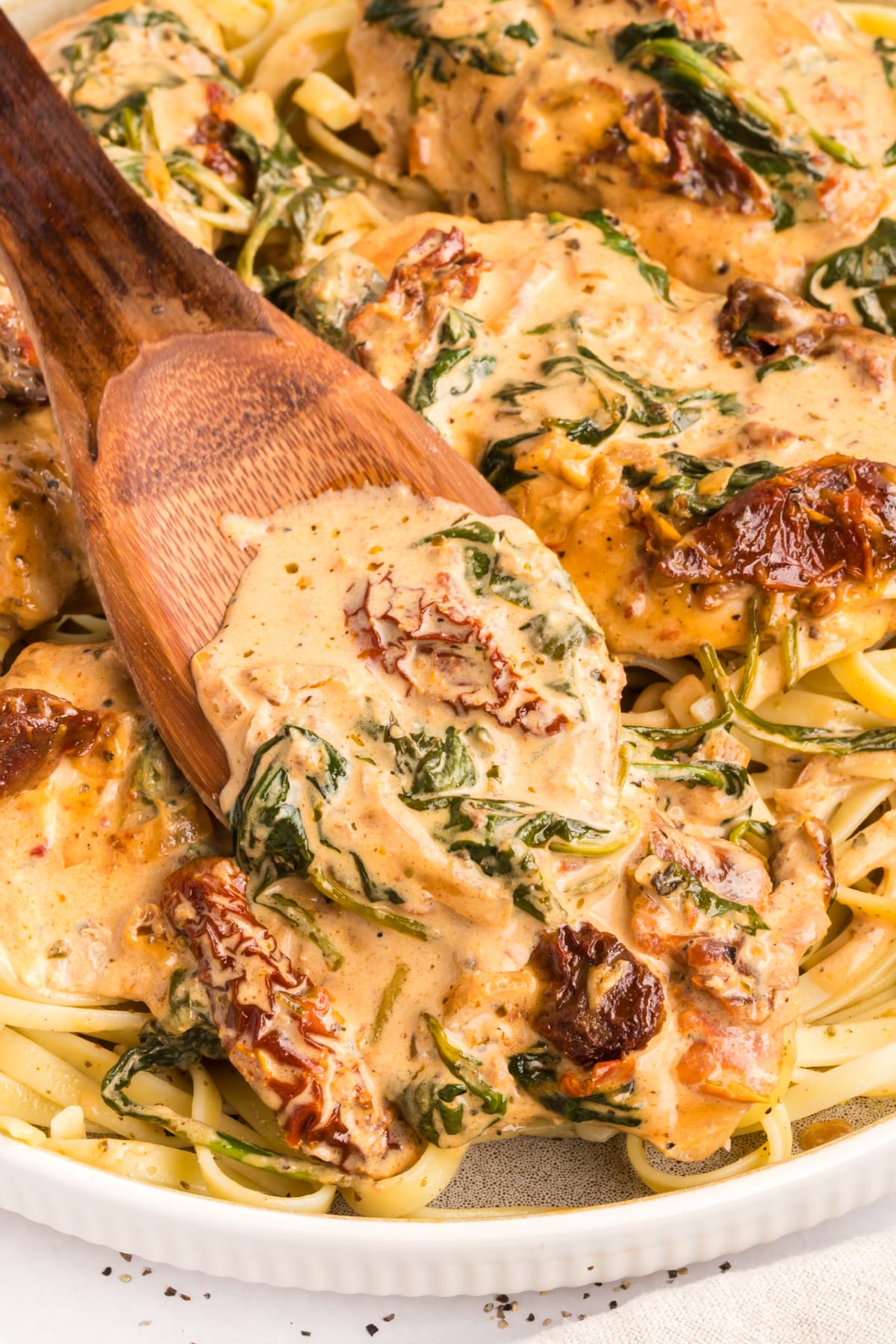Marry Me Tuscan Chicken with creamy sauce over pasta Marry Me Tuscan Chicken served over pasta with creamy parmesan sauce, sun-dried tomatoes, and spinach