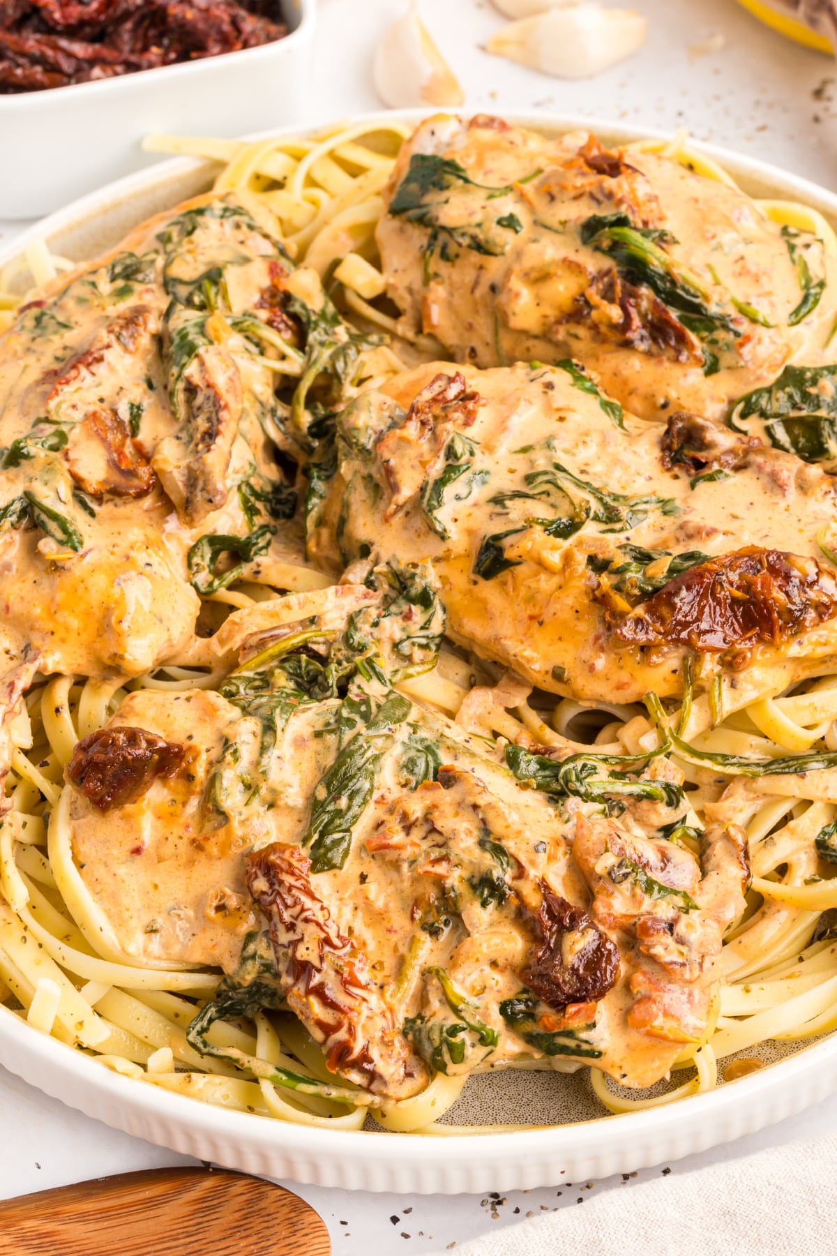 Marry Me Tuscan Chicken with sun-dried tomatoes, spinach, and creamy parmesan sauce over pasta