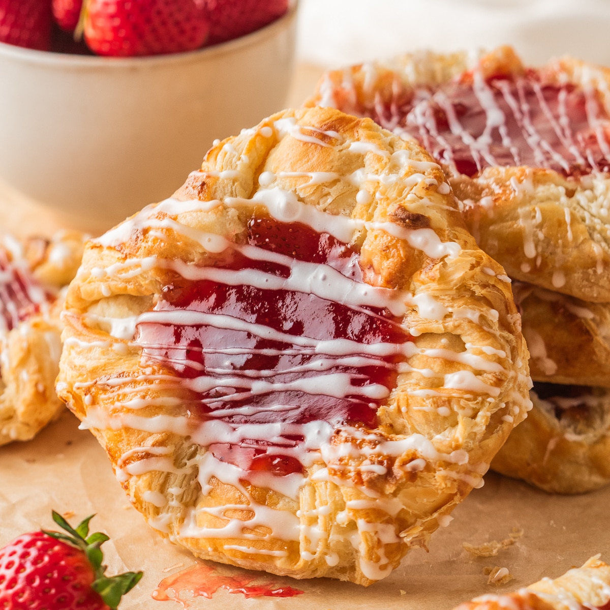 puff pastry strawberry danish with cream cheese filling and glaze served with fresh strawberries