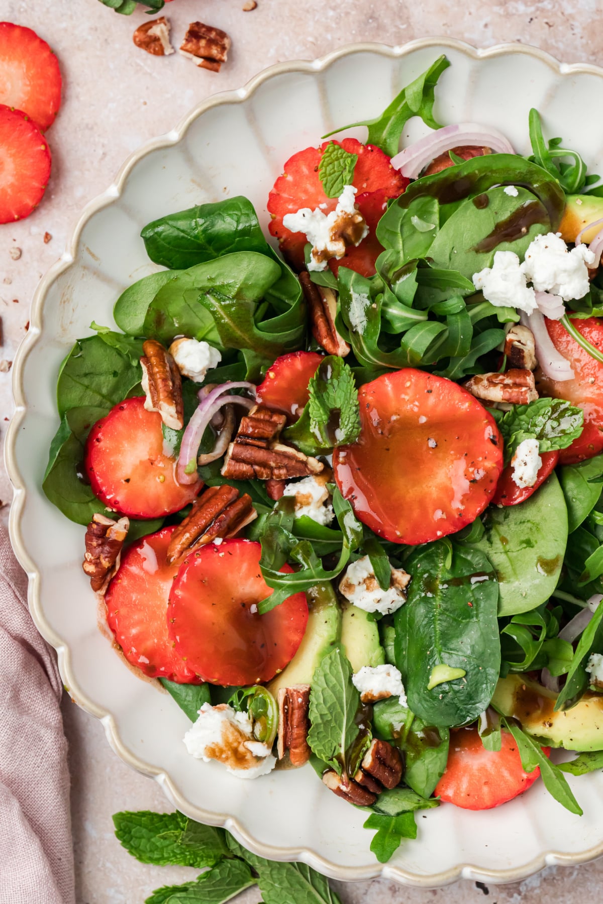 Strawberry Spinach Goat Cheese Salad with Avocado and Pecans Strawberry spinach goat cheese salad with avocado, pecans, mint, and balsamic vinaigrette in a serving bowl