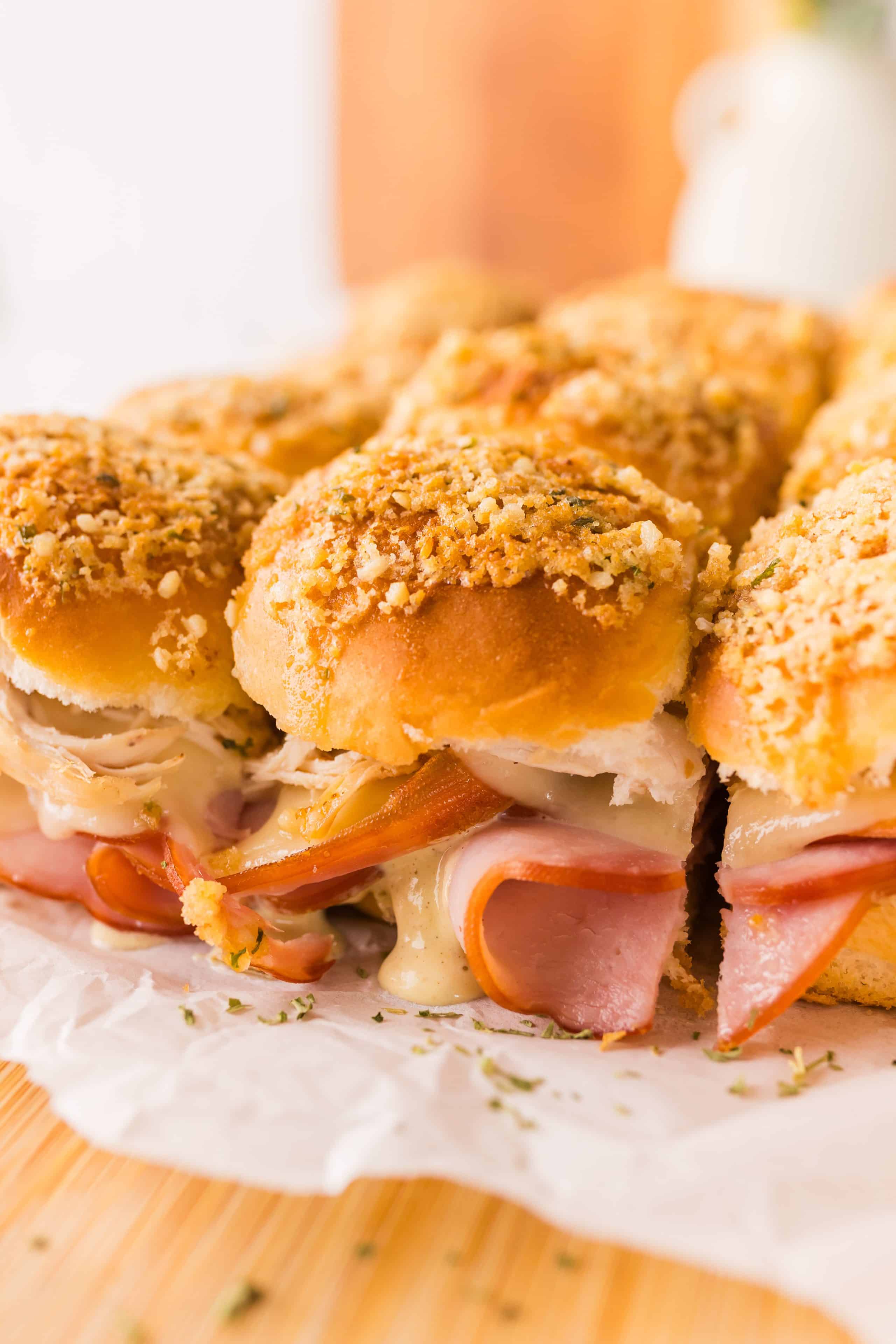Chicken cordon bleu sliders with melted Swiss cheese, folded ham, shredded chicken, and a crispy garlic panko topping on Hawaiian rolls