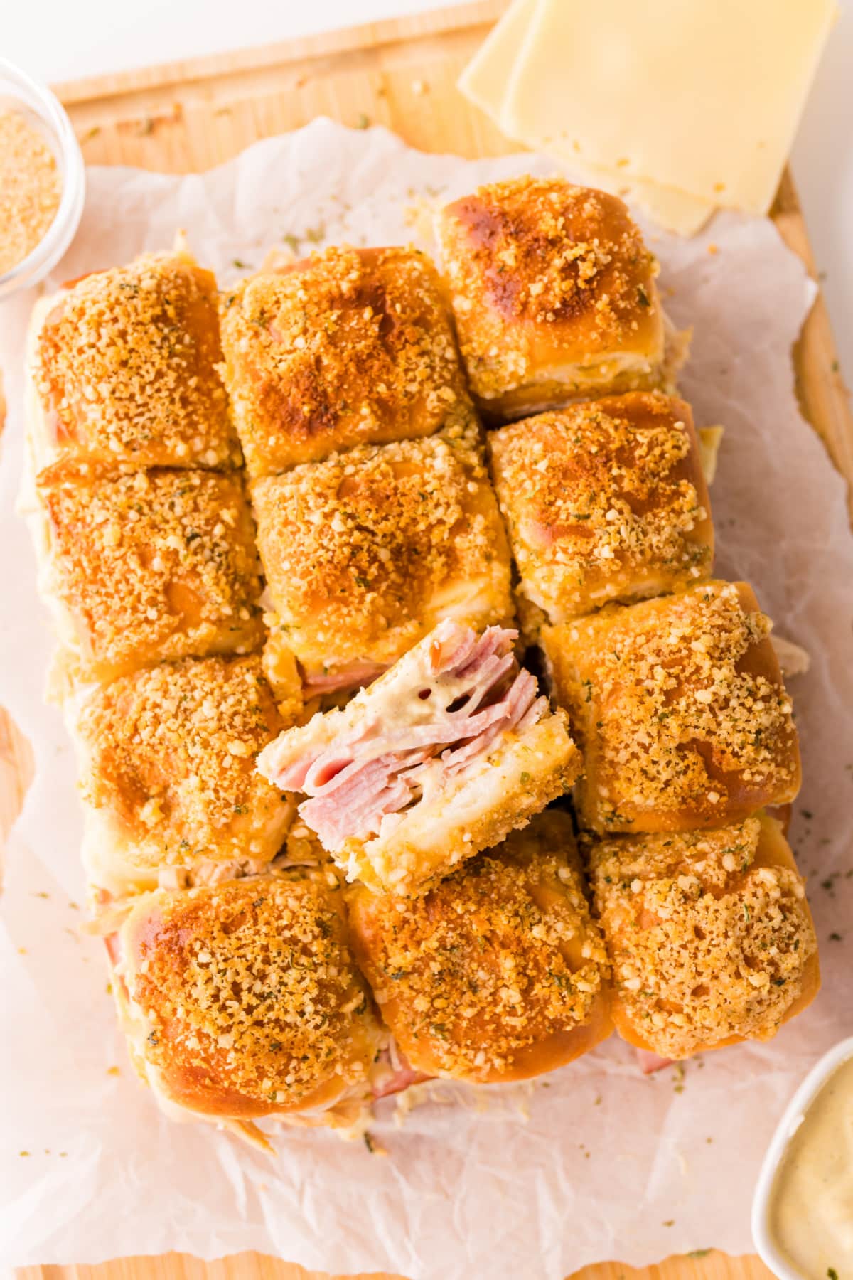 Overhead view of baked cordon bleu sliders with crispy panko topping and layers of ham, Swiss cheese, and chicken