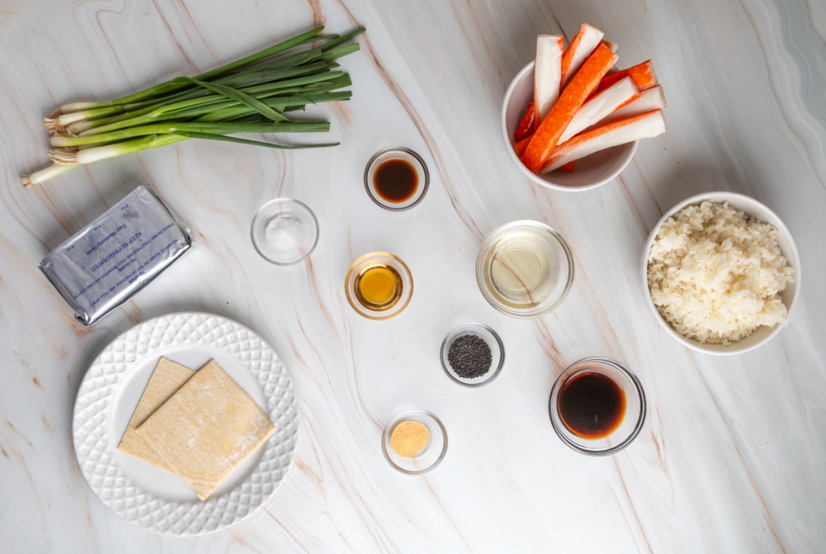 Ingredients for Crispy Rice Crab Rangoon Bites including sushi rice, imitation crab, cream cheese, green onions, soy sauce, and wonton wrappers