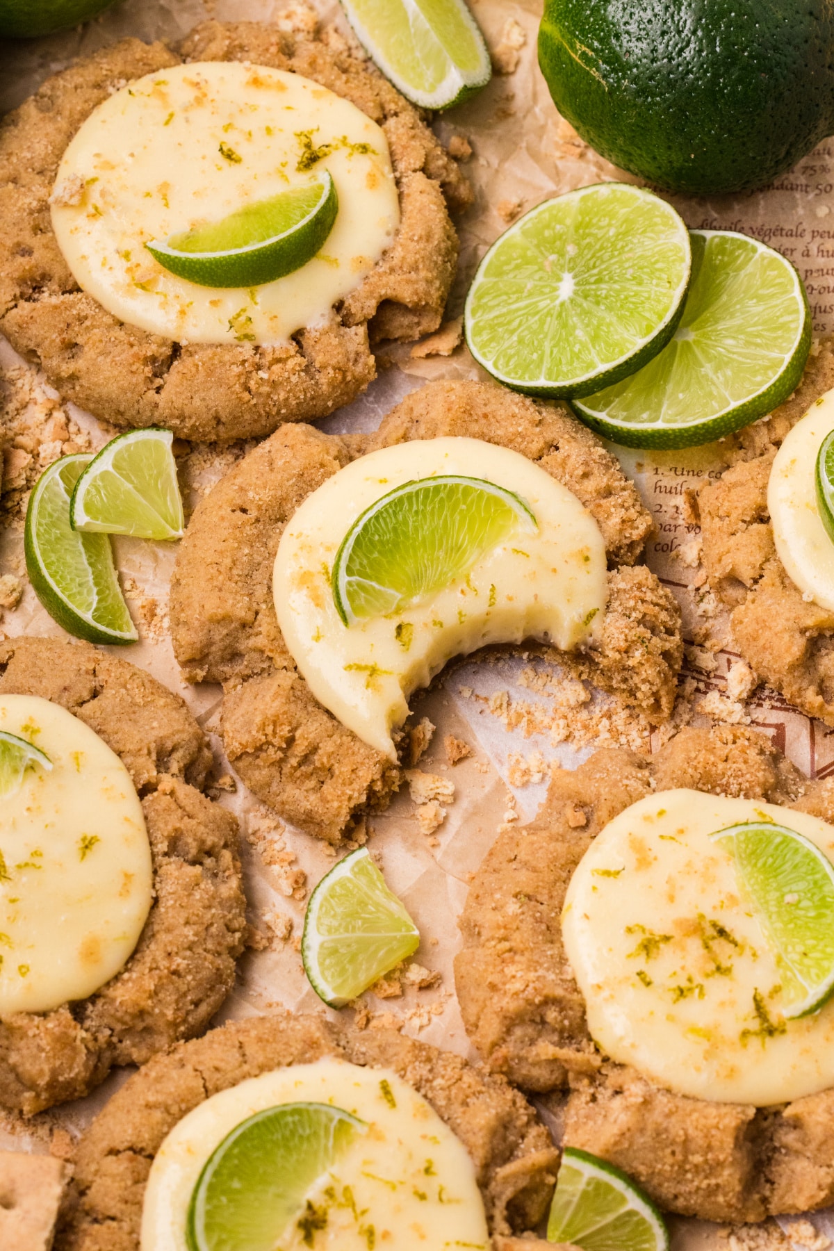 Key lime pie cookies with creamy lime filling, graham cracker crumb topping, and fresh lime slices