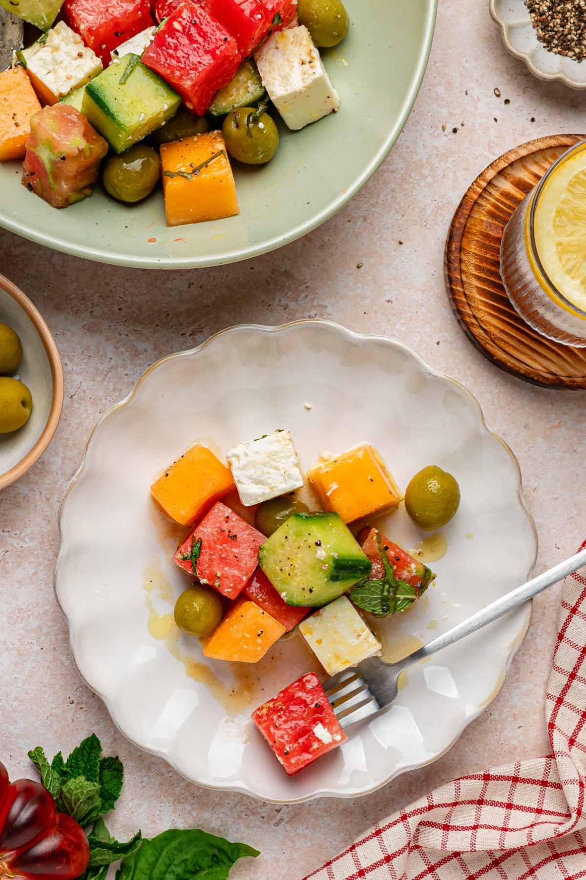 melon and feta salad with cucumber, olives, and herbs served on a plate