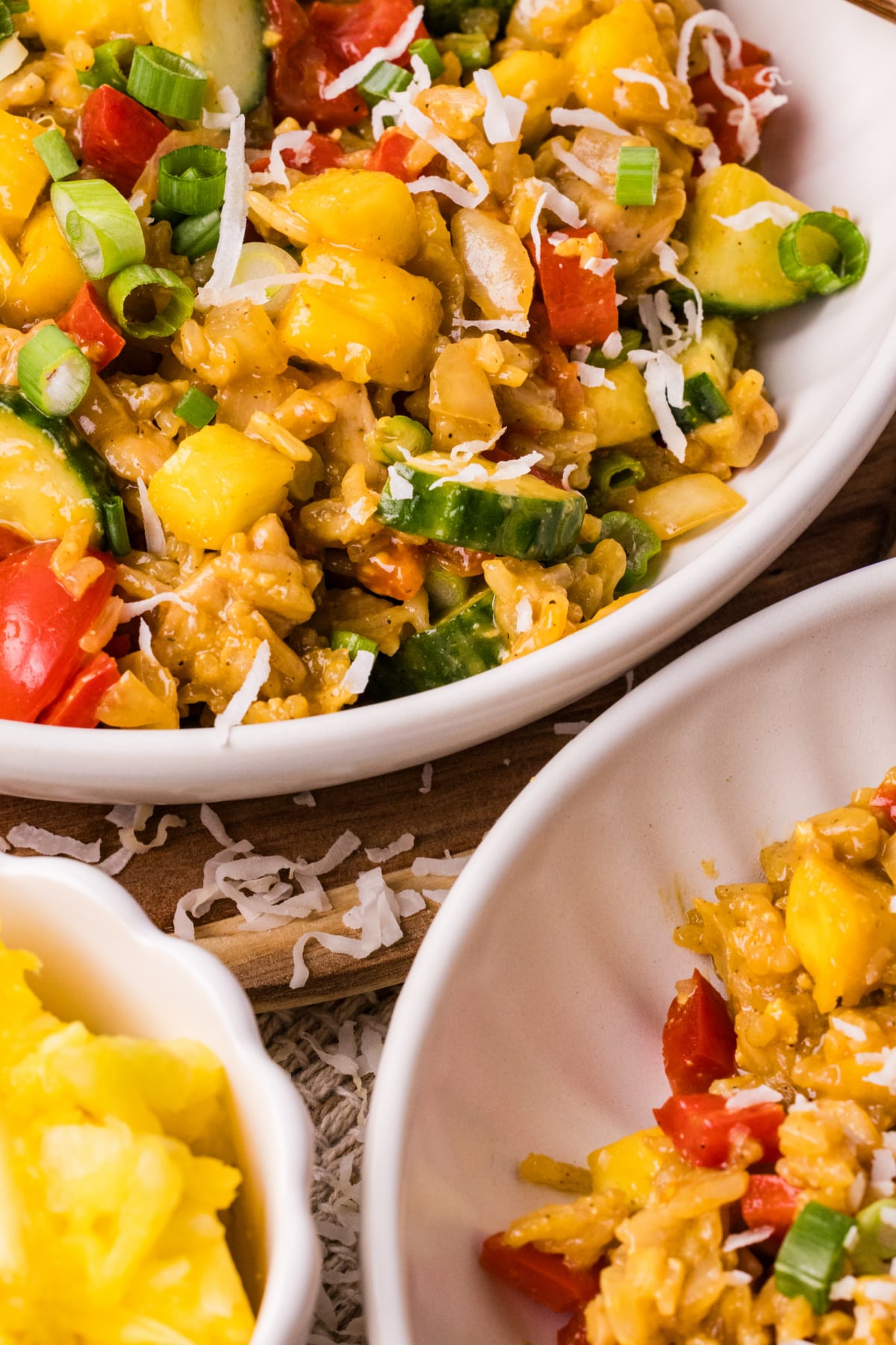 pineapple chicken fried rice with coconut rice, fresh pineapple, cucumber, and green onions close up