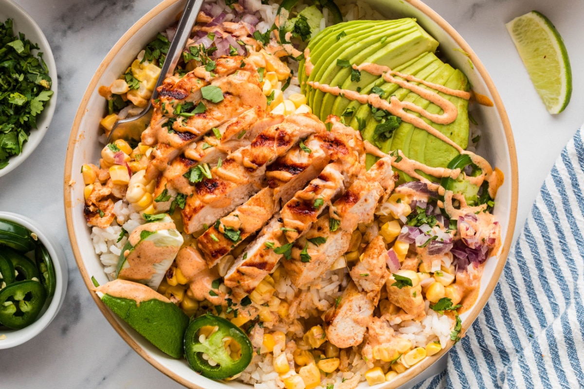 street corn chicken rice bowls with grilled chicken, avocado, charred corn, jalapeños, and creamy elote-style sauce