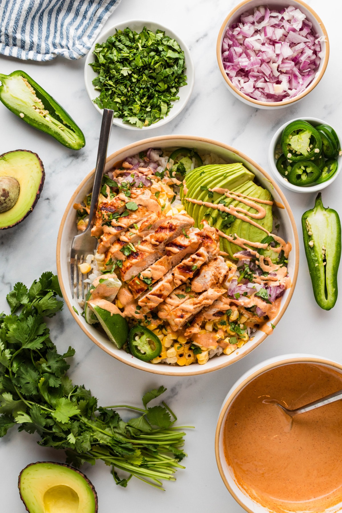 street corn chicken rice bowls with grilled chicken, charred corn, avocado, cilantro, jalapeños, and creamy elote-style sauce