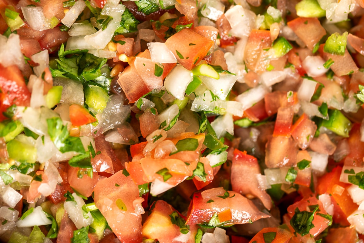 Close-up of chunky homemade pico de gallo with diced tomatoes, onion, jalapeño, cilantro, and lime juice