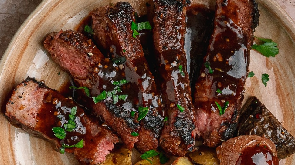 New York strip steak with pan sauce Cocoa rubbed steak with dark stout pan sauce sliced and covered in dark savory pan sauce.