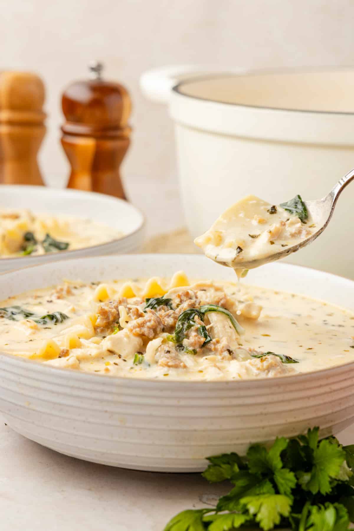 Creamy white chicken lasagna soup with sausage, spinach, ricotta, and lasagna noodles in a rich white broth