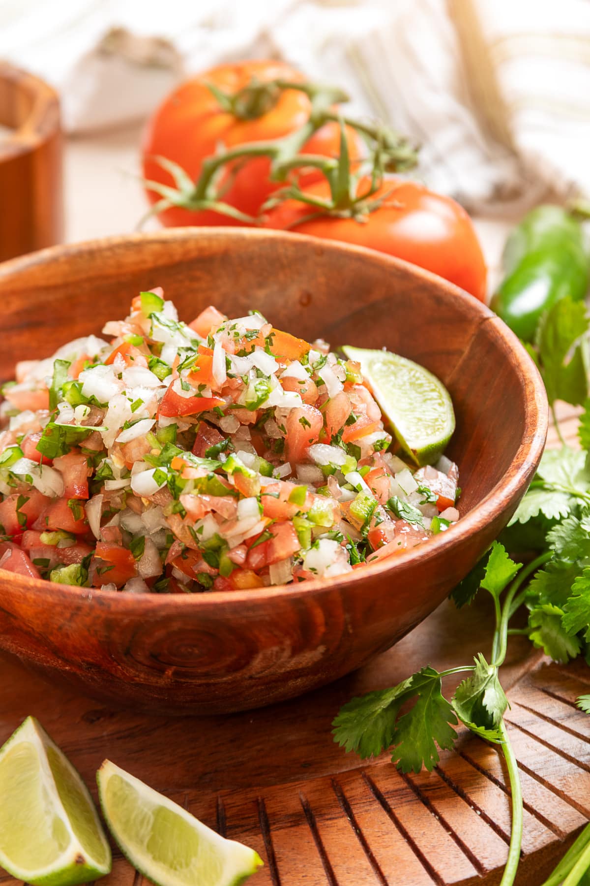 Fresh pico de gallo with diced tomatoes, onion, jalapeño, cilantro, and lime served in a wooden bowl
