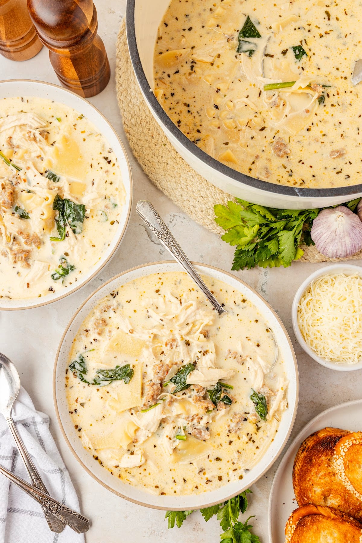 Lasagna soup with ricotta, spinach, sausage, chicken, and broken lasagna noodles served in bowls with creamy white broth