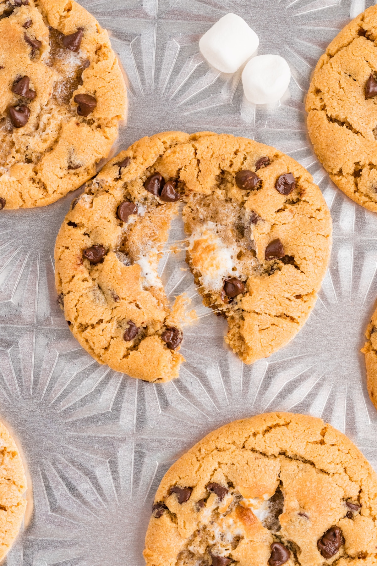 Pull-apart peanut butter cookie with melted marshmallow stretching between the halves and mini chocolate chips throughout.