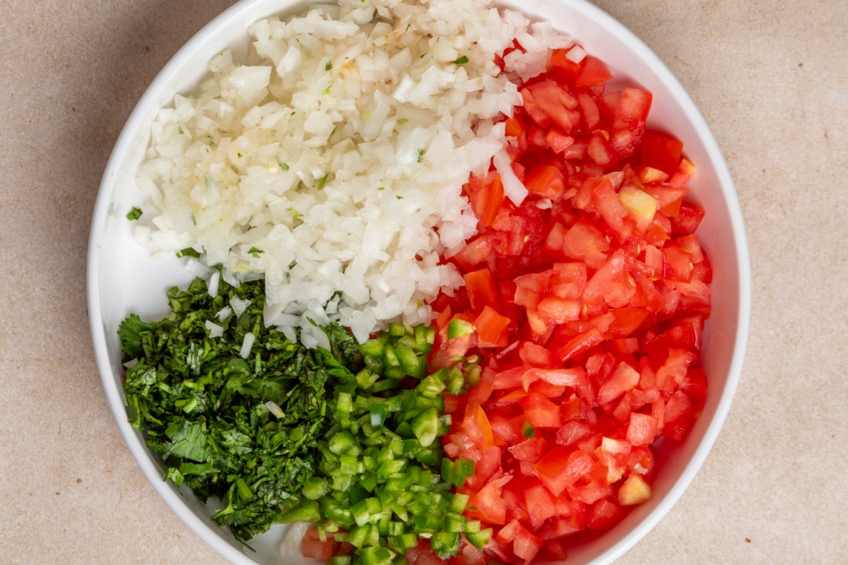 Diced tomatoes, white onion, jalapeño, garlic, and cilantro prepared for homemade pico de gallo