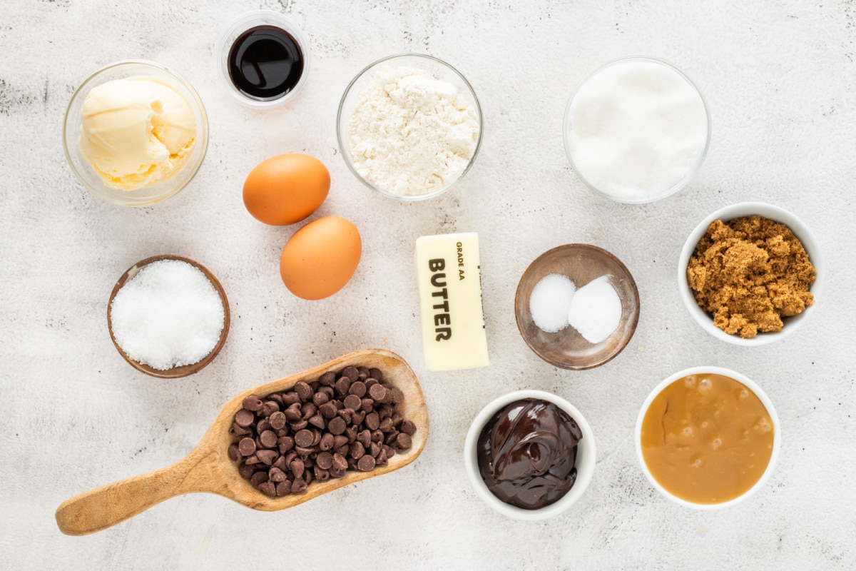 Salted caramel sauce, chocolate chips, and flaky sea salt are what push this skillet cookie into lava-style dessert territory. Ingredients for salted caramel chocolate chip skillet cookie including chocolate chips, salted caramel sauce, butter, brown sugar, eggs, flour, and flaky sea salt.