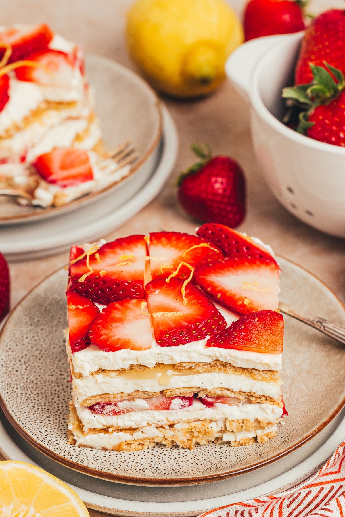 Slice of strawberry lemon icebox cake with lemon curd and strawberries Slice of strawberry lemon icebox cake on a plate with mascarpone cream, lemon curd, strawberries, and softened graham cracker layers.