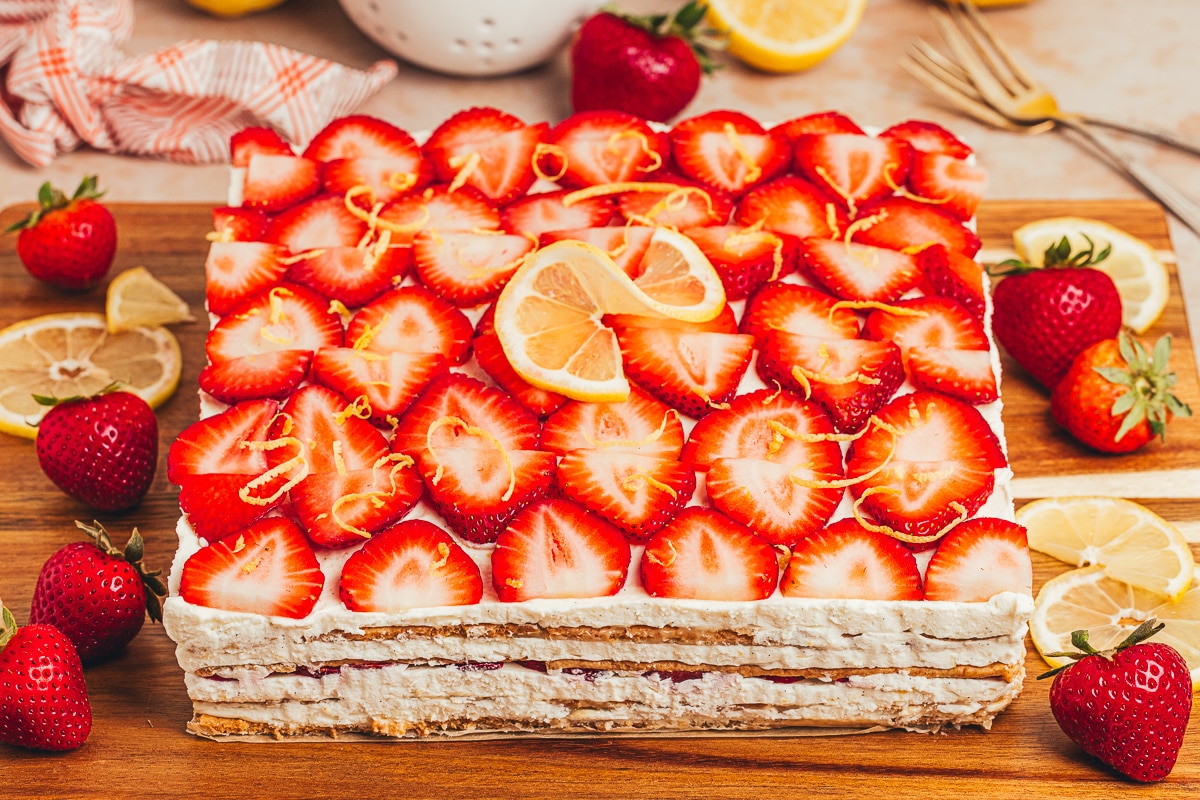 Whole strawberry lemon icebox cake topped with fresh strawberries and lemon Whole strawberry lemon icebox cake topped with fresh strawberries, lemon slices, mascarpone cream, and graham cracker layers.