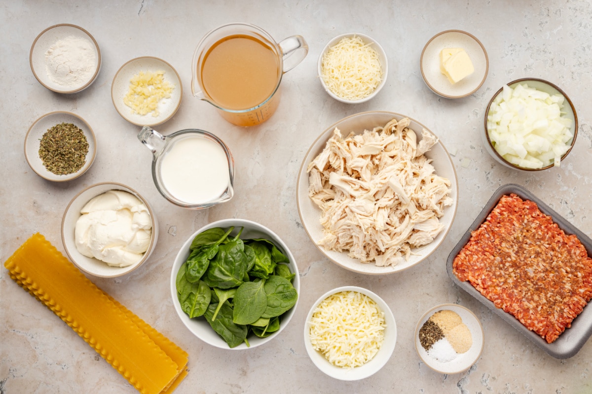 Ingredients for White Lasagna Soup including sausage, chicken, spinach, ricotta, mozzarella, Parmesan, lasagna noodles, cream, and chicken stock