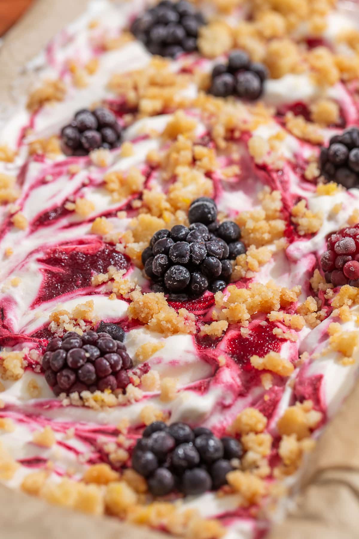 Close-up of homemade no-churn blackberry ice cream with thick blackberry swirls, buttery shortbread crumble, and whole blackberries.