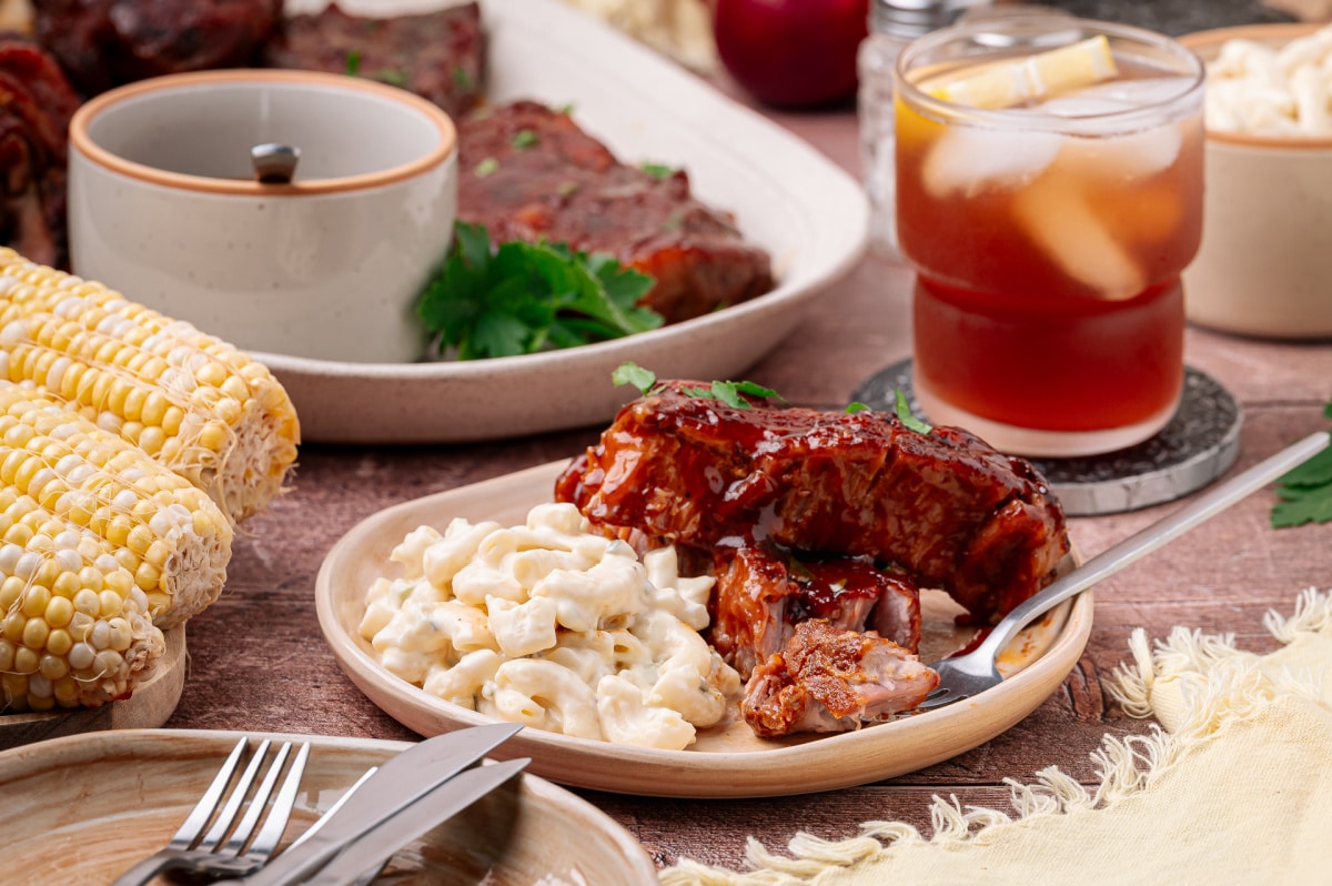 Bourbon peach country style ribs served with macaroni salad and corn on the cob