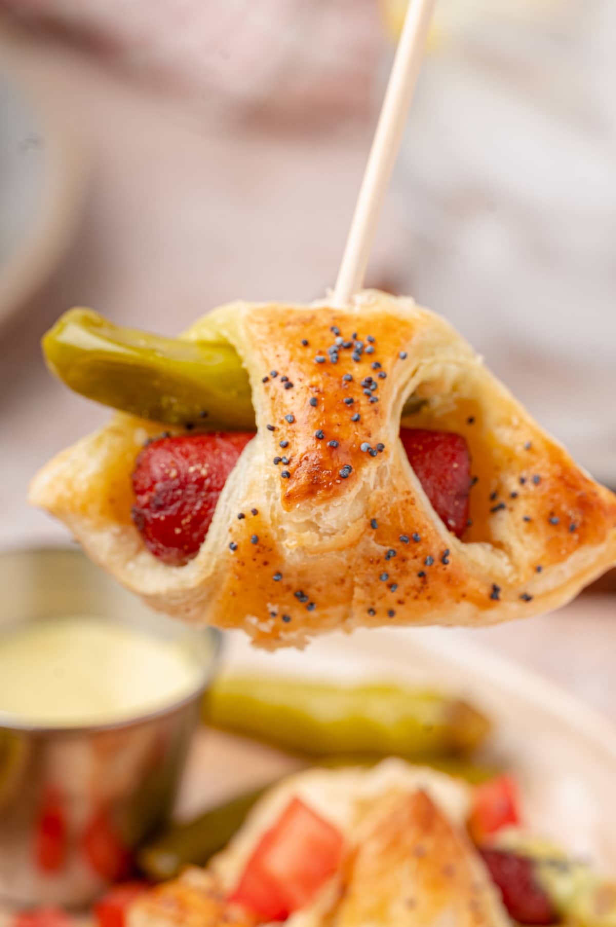 Chicago hot dog pigs in a blanket with a sport pepper and beef cocktail frank held on a toothpick.
