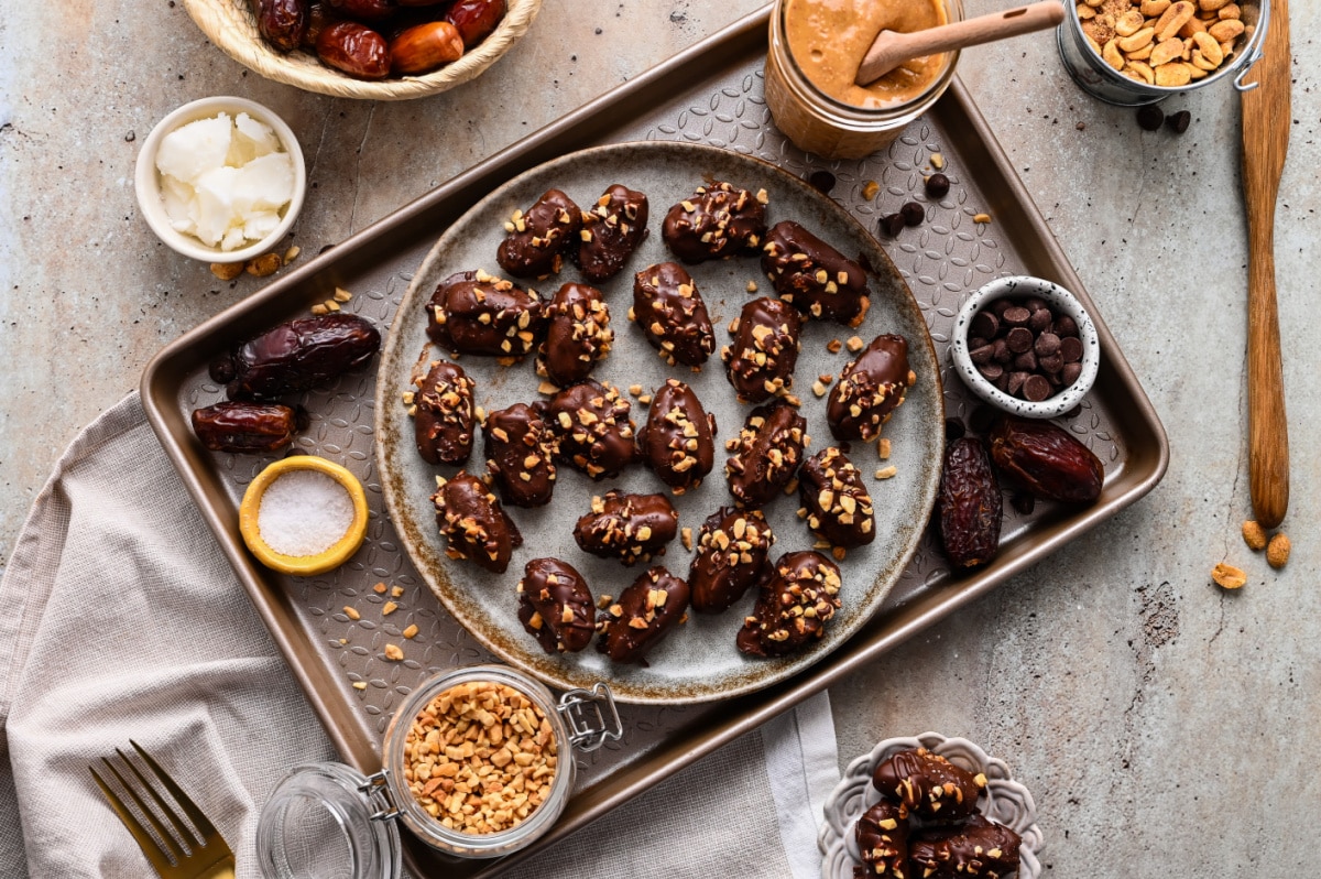 Overhead serving platter of chocolate peanut butter stuffed dates Overhead view of chocolate peanut butter stuffed dates topped with chopped peanuts and flaky sea salt