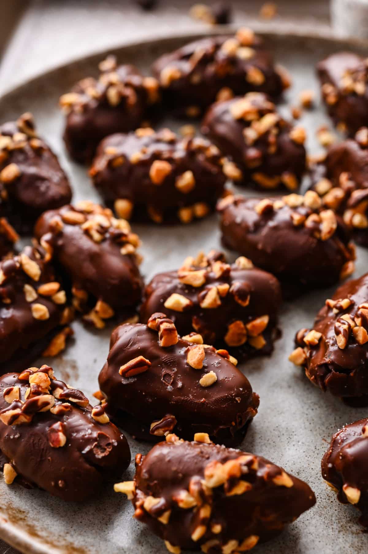 Chocolate peanut butter stuffed dates ready to serve Chocolate peanut butter stuffed dates topped with chopped peanuts on a serving platter