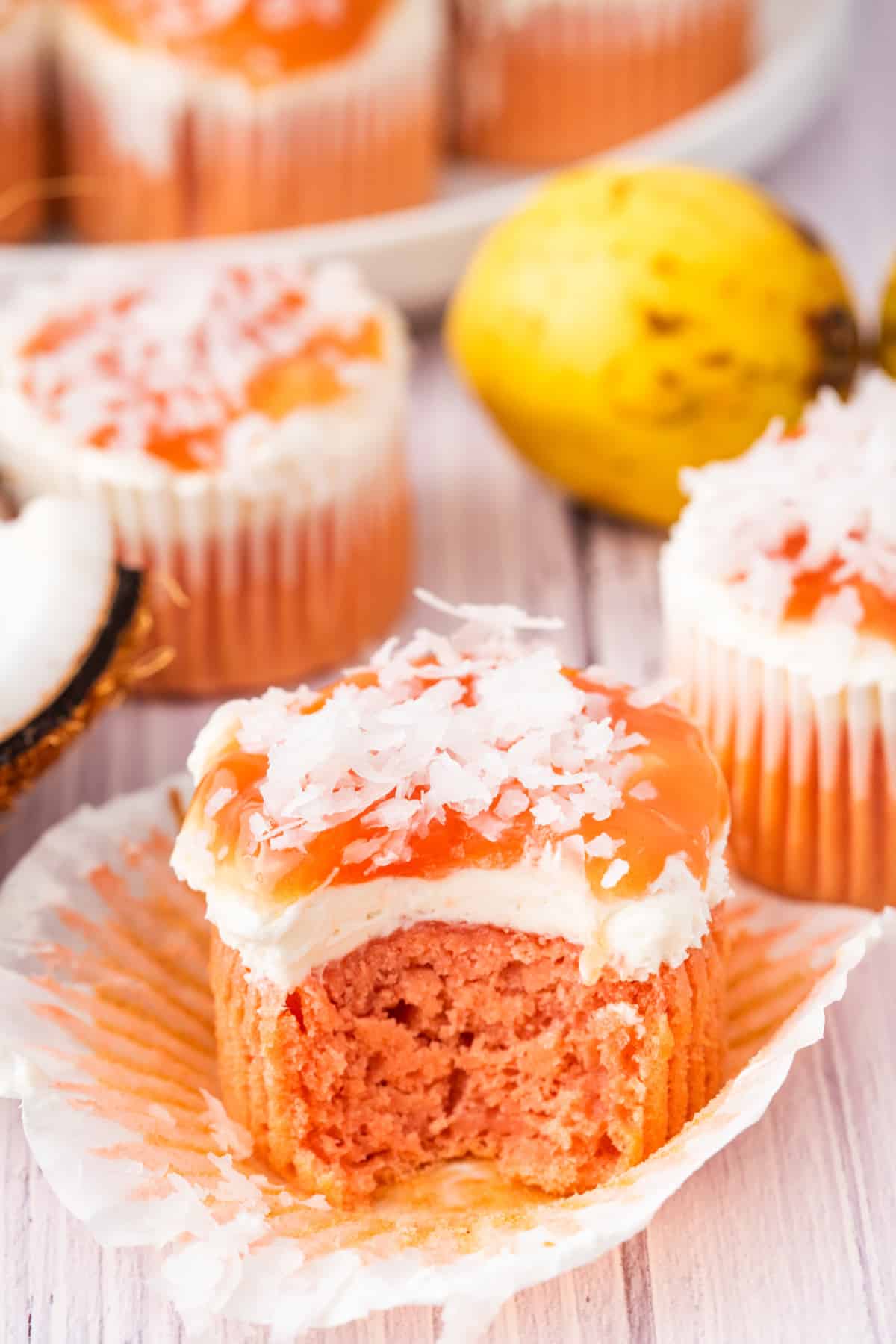 These guava glazed cream cheese cupcakes are inspired by Hawaiian guava cake with pink cake, a cream cheese layer, guava glaze, and coconut. Guava glazed cream cheese cupcake topped with cream cheese frosting, guava glaze, and shredded coconut