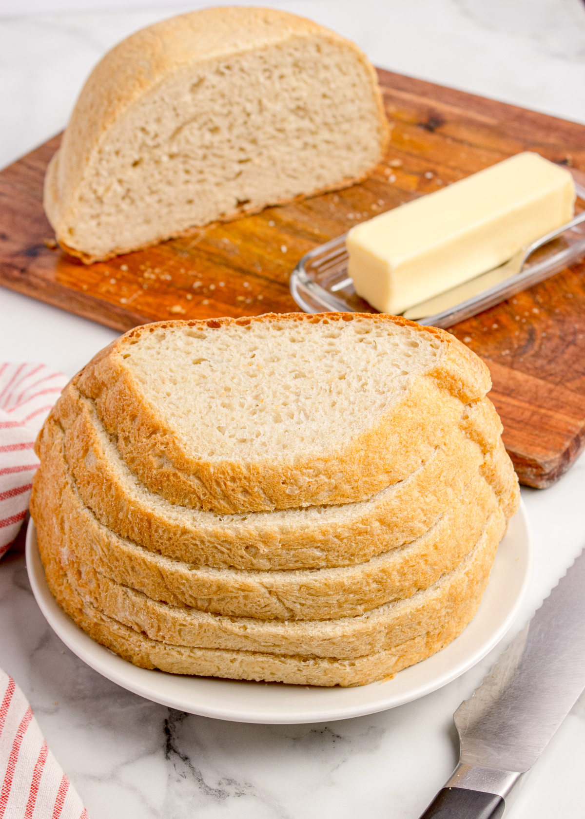 Homemade peasant bread loaf sliced and served with butter