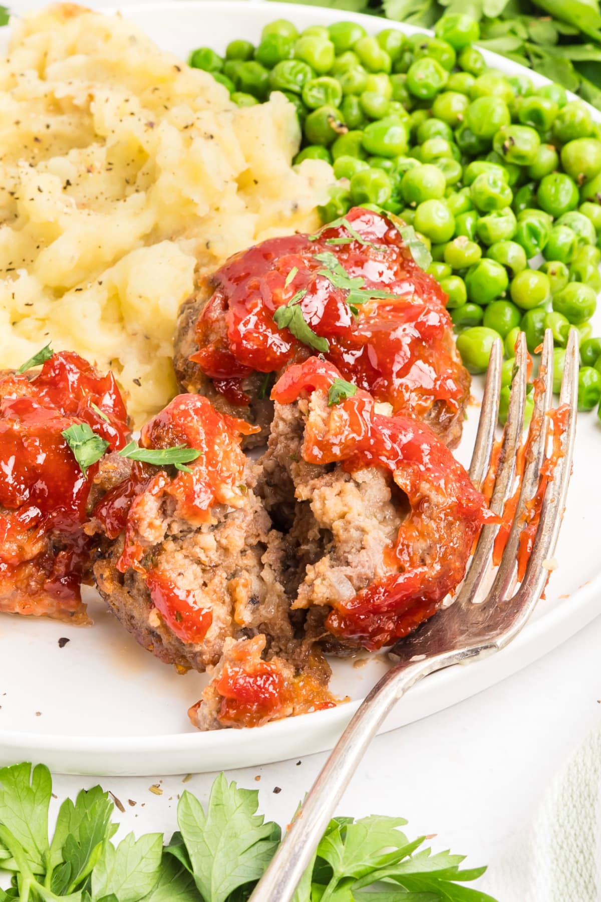 Mini meatloaf broken open to show the interior texture Inside of a mini meatloaf showing the tender texture beneath the tomato glaze