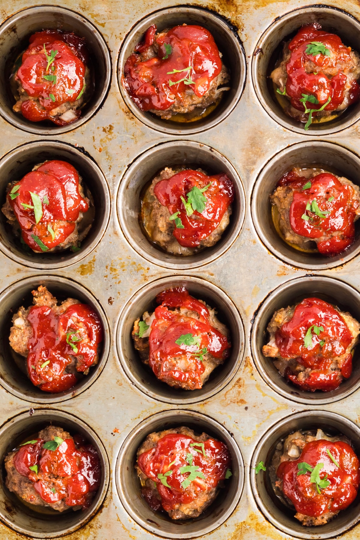 Mini meatloaf recipe with caramelized edges and tomato glaze Mini meatloaf recipe baked in a muffin tin with caramelized tomato glaze