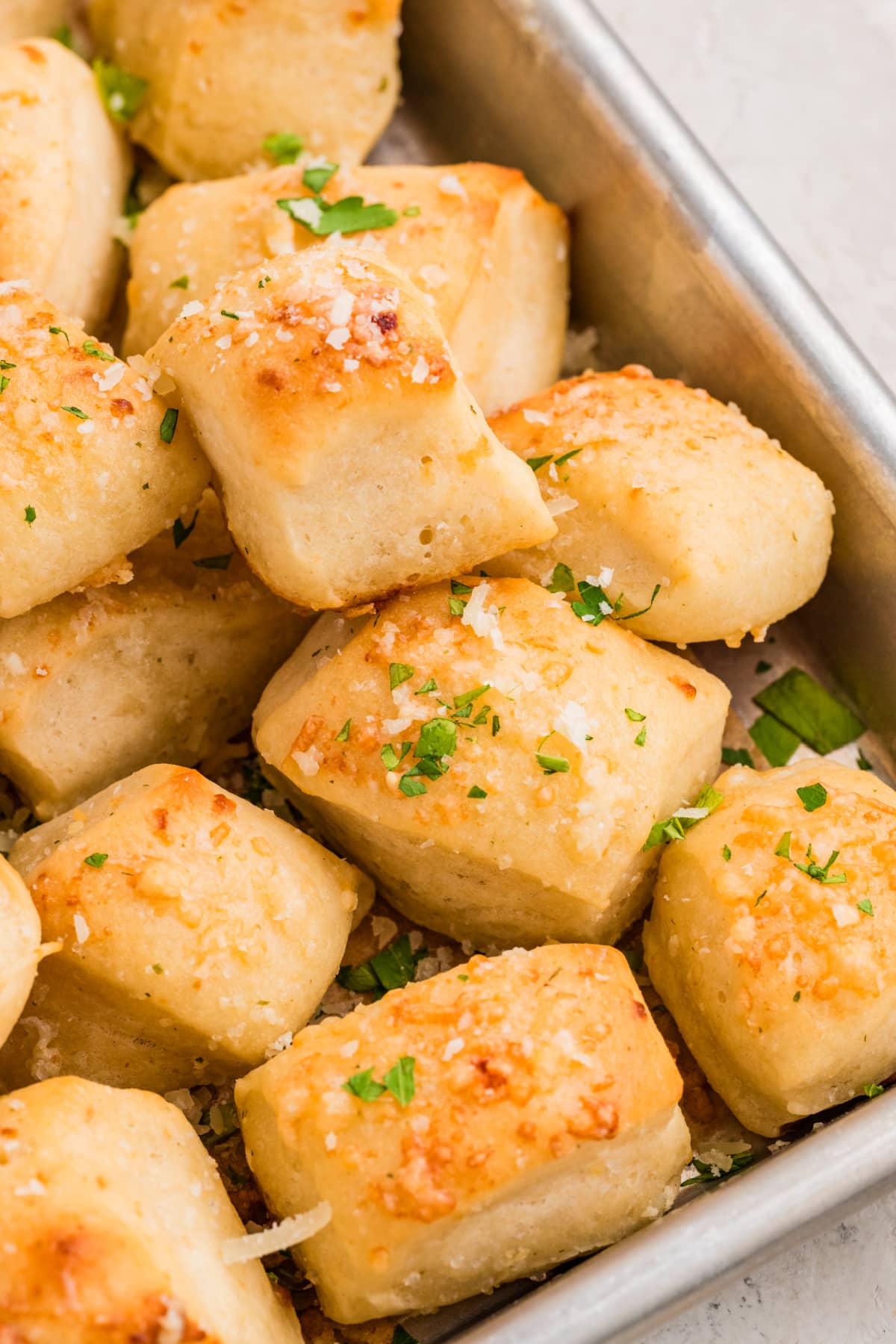 Close-up of Parmesan bread bites showing their soft interior and golden Parmesan topping