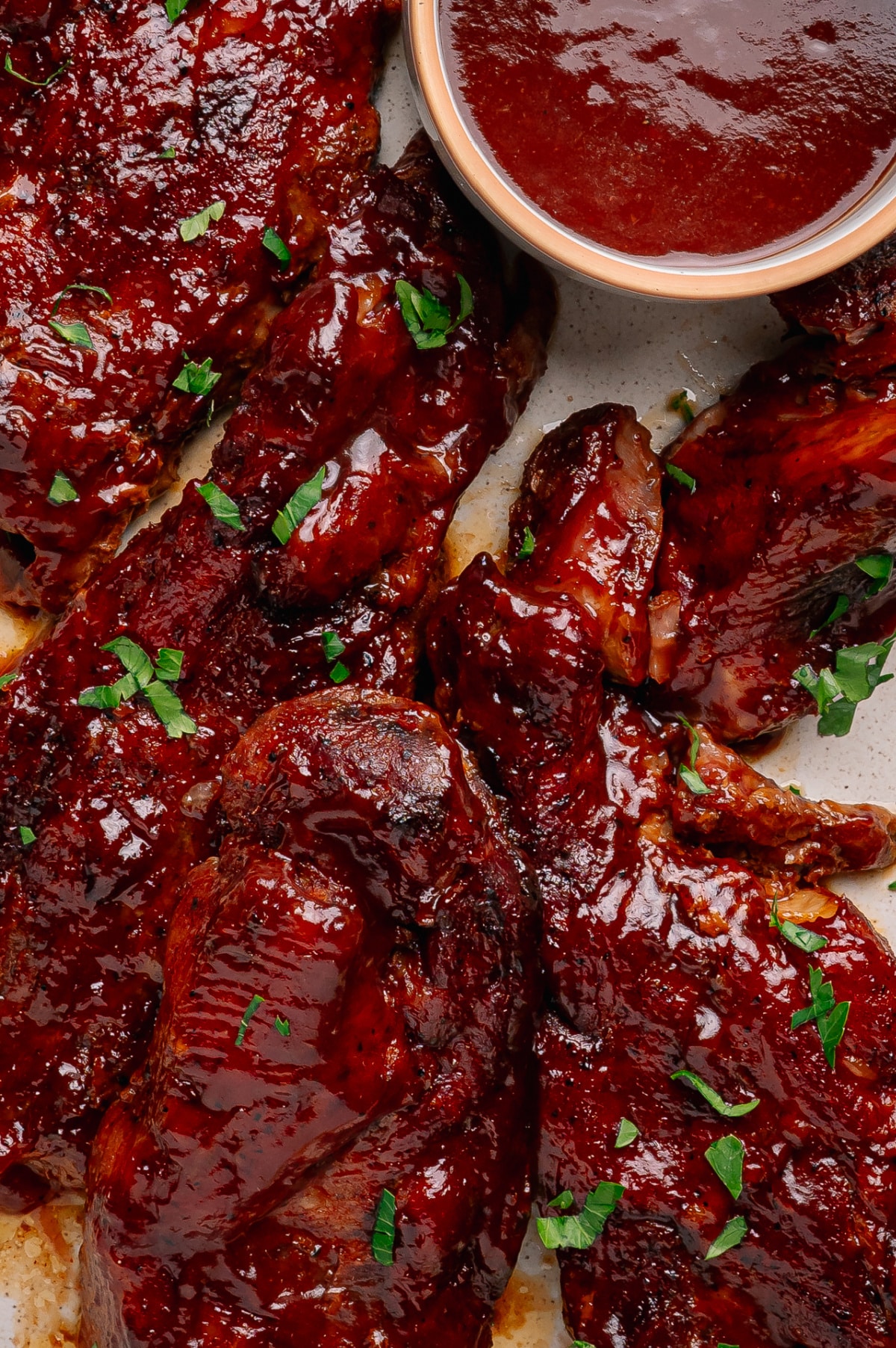 Country style pork ribs coated in peach bourbon barbecue sauce with extra glaze served on the side