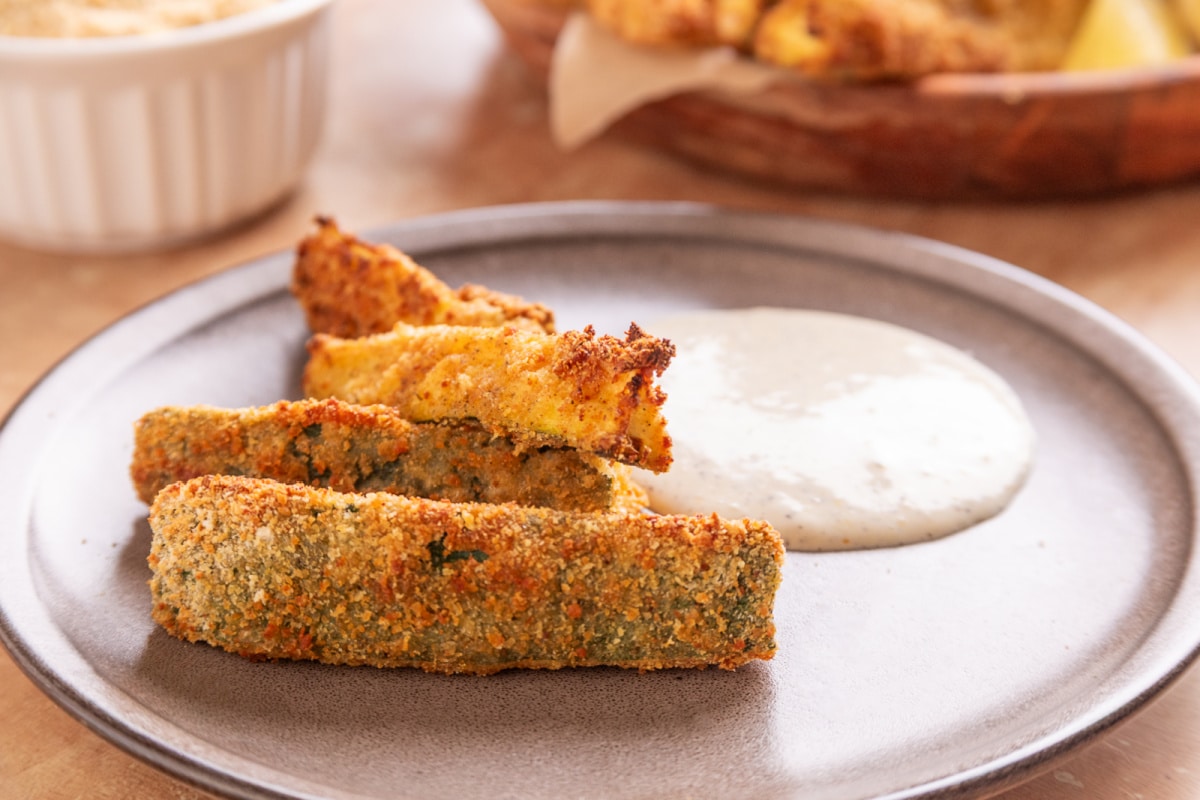 Air Fryer Zucchini Fries served with homemade lemon garlic aioli on a plate.