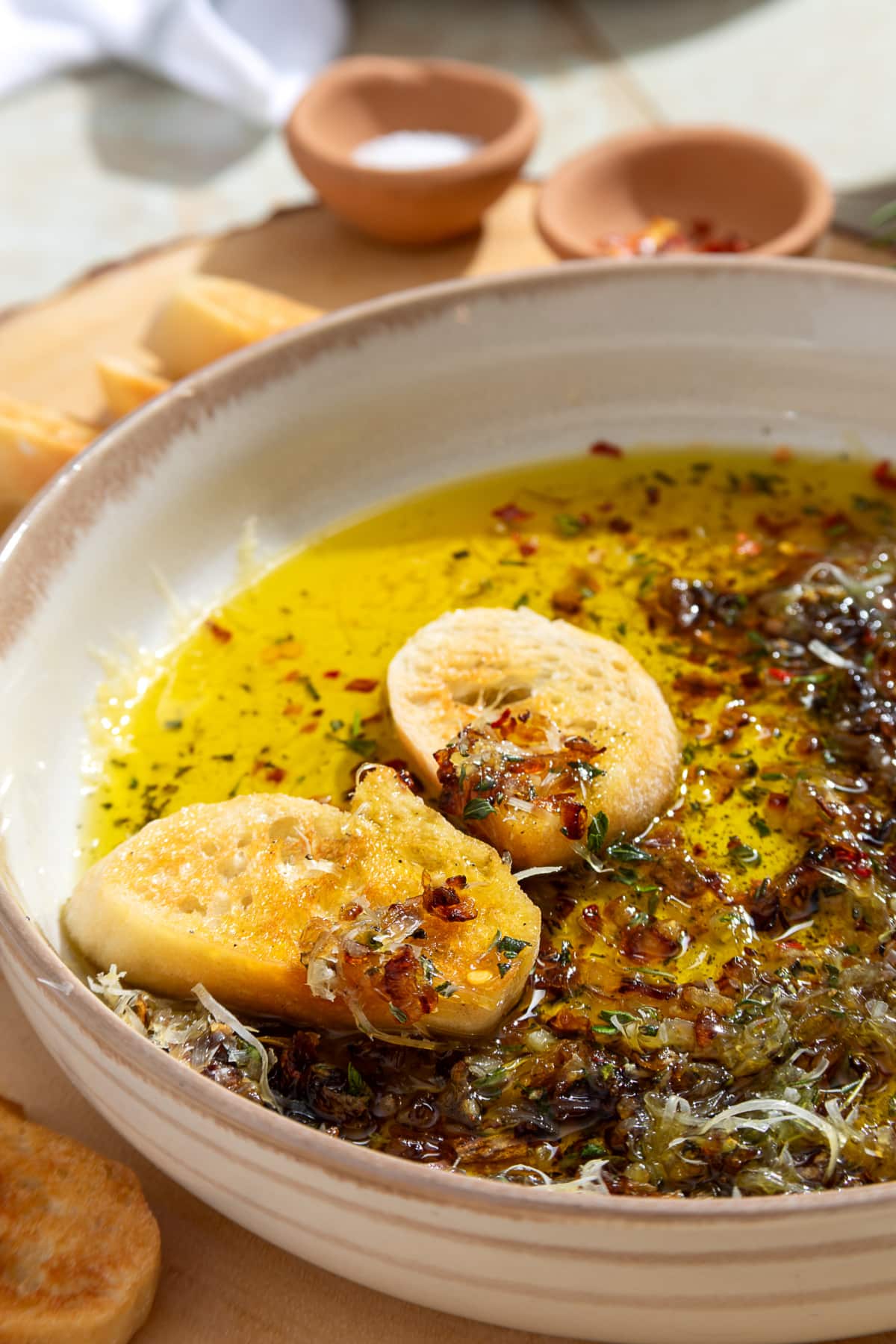 Bread dipping oil with caramelized shallots, fresh herbs, Parmesan, and toasted bread.