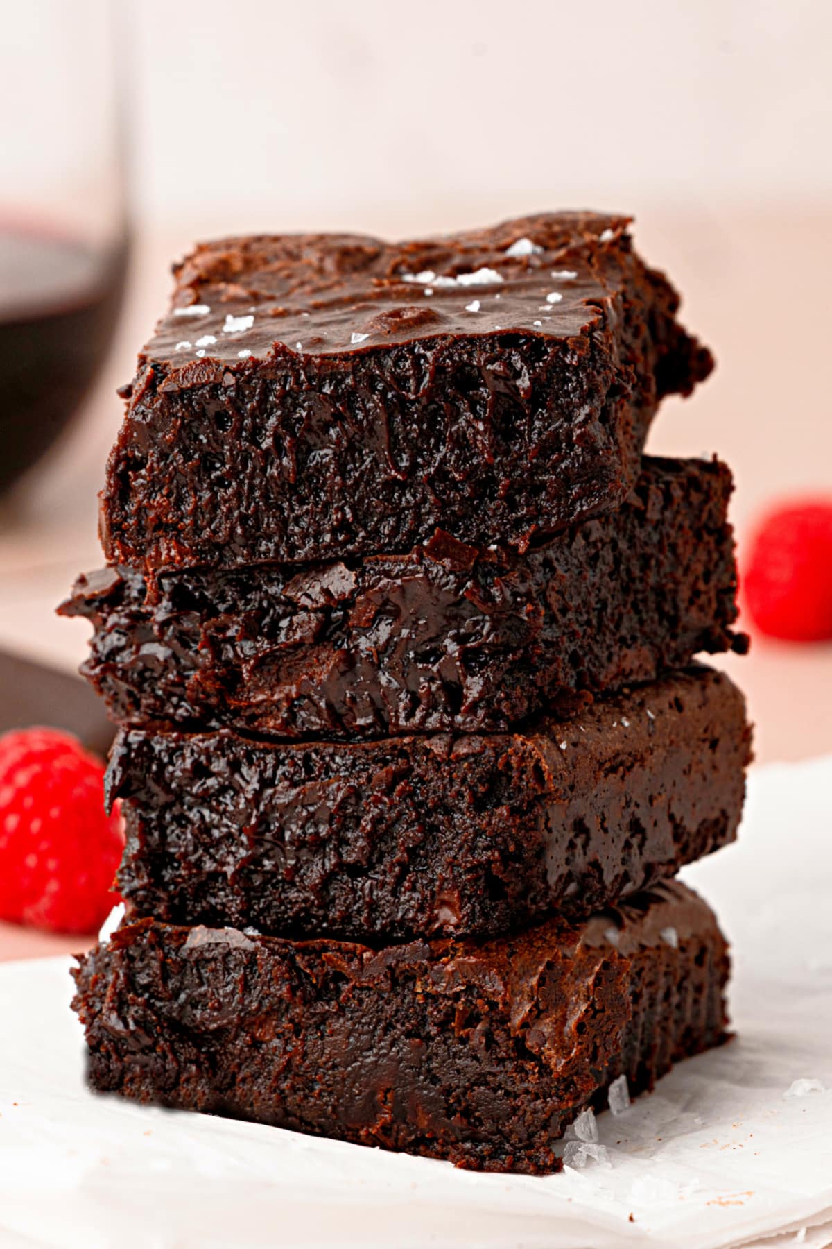 Cabernet Sauvignon brown butter brownies stacked on parchment with flaky sea salt.